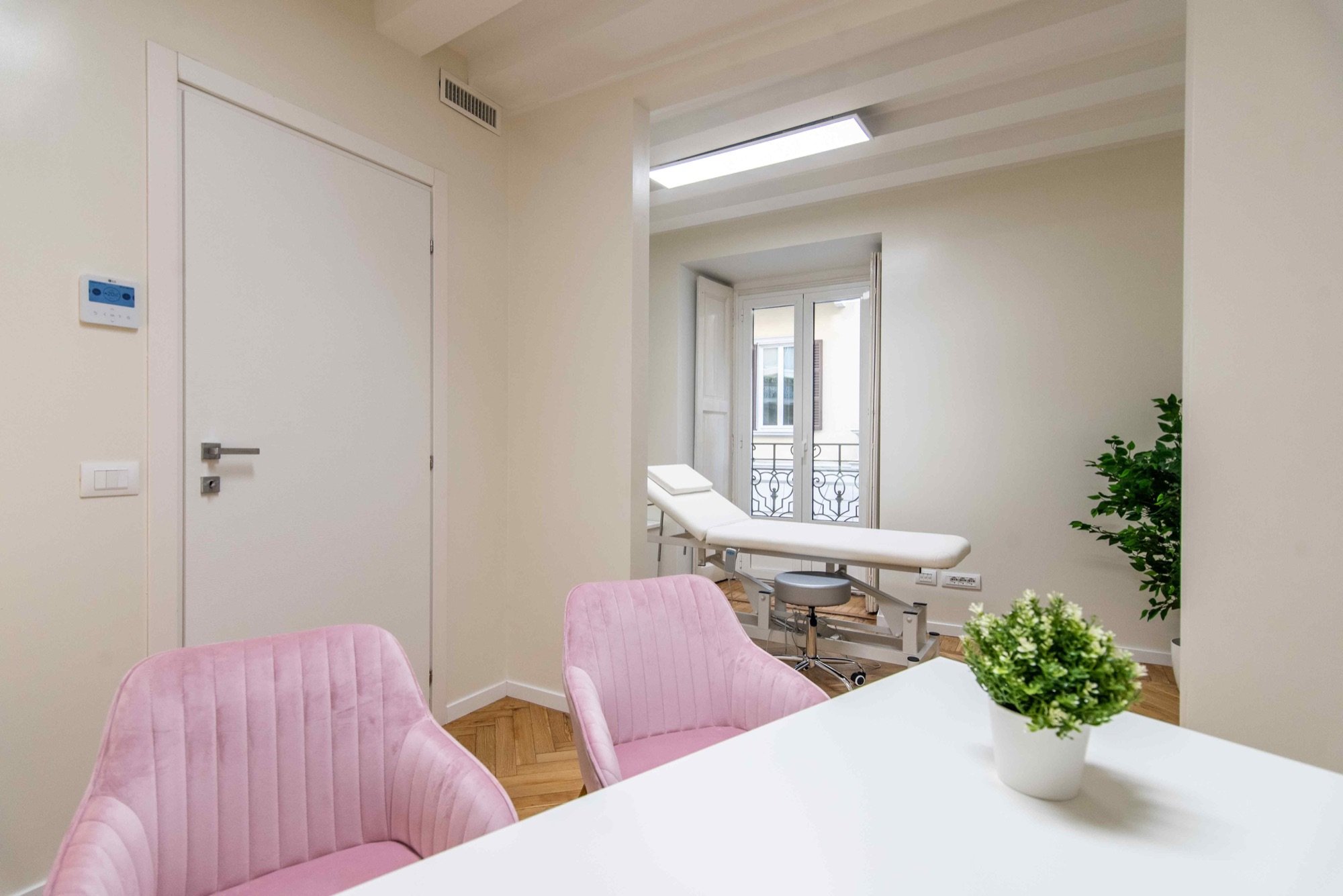 Area colloquio con scrivania e poltroncine, lettino sullo sfondo in ambulatorio medico Exclusive presso Spatium Brera, Milano