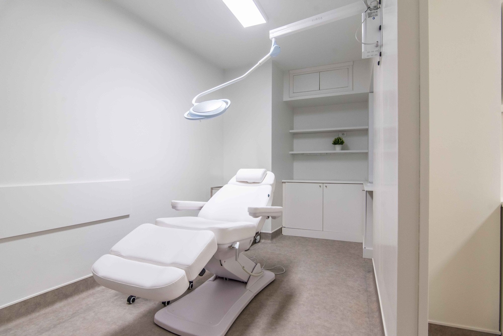 Poltrona estetica reclinabile con lampada e scaffalatura in ambulatorio medico Exclusive presso Spatium Brera, Milano