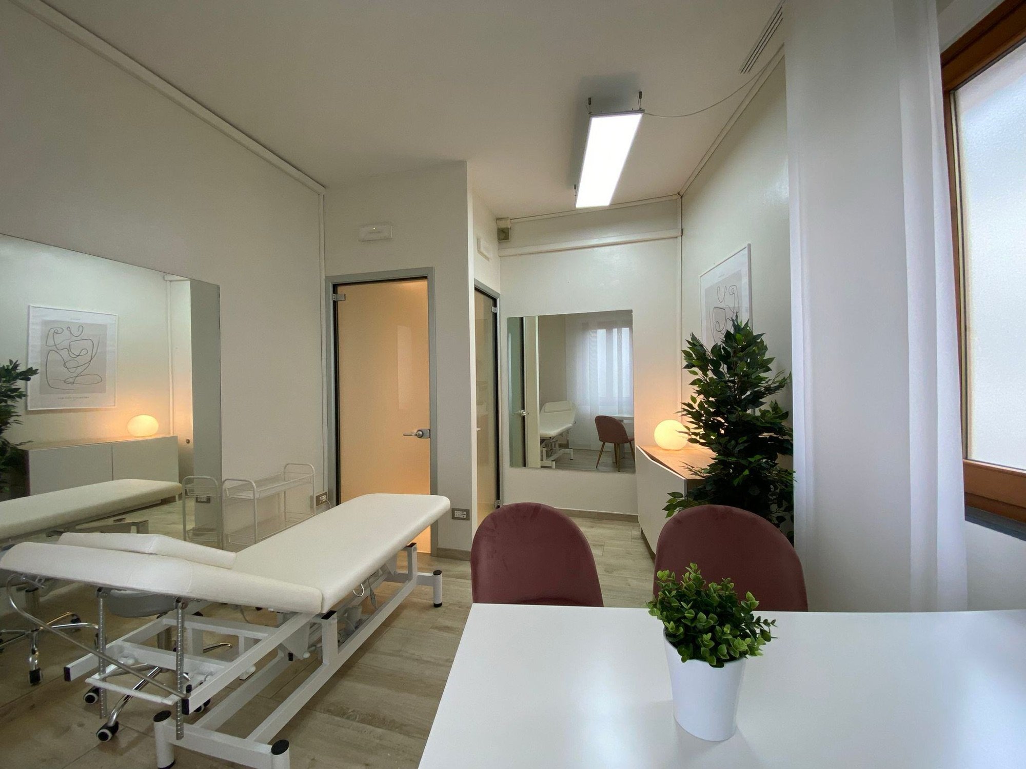 Lettino da visita con tavolo in primo piano e lampada in studio olistico Exclusive presso Spatium Porta Romana, Firenze