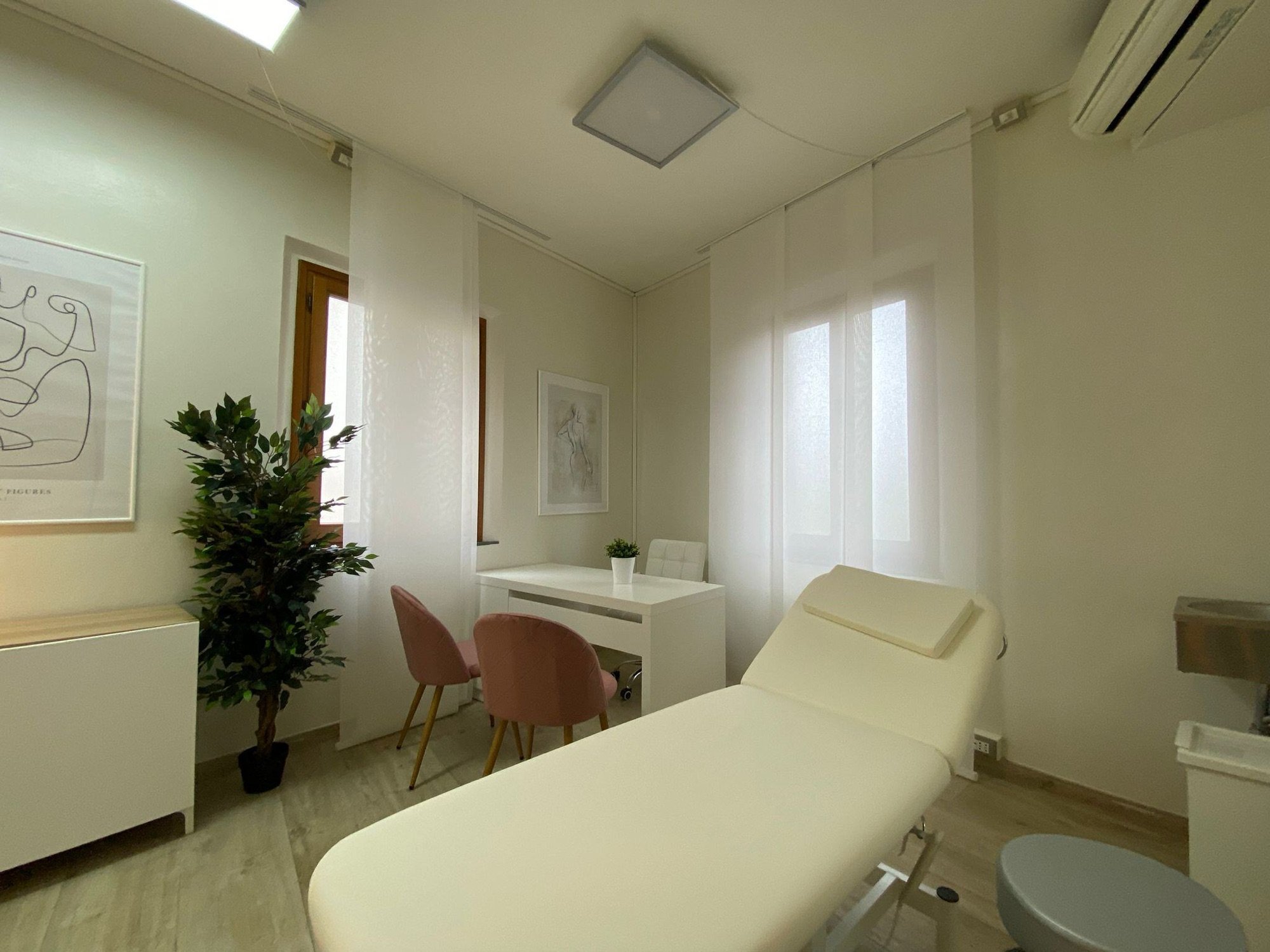 Lettino da visita in primo piano con tavolo e pianta in studio olistico Exclusive presso Spatium Porta Romana, Firenze