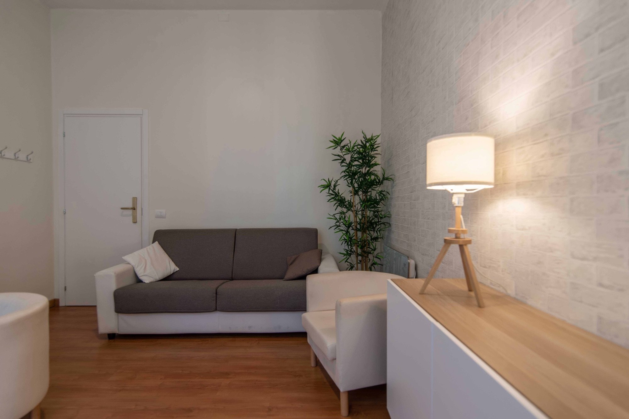 Divano con arredi e lampada da terra in studio olistico Exclusive presso Spatium Caiazzo, Milano