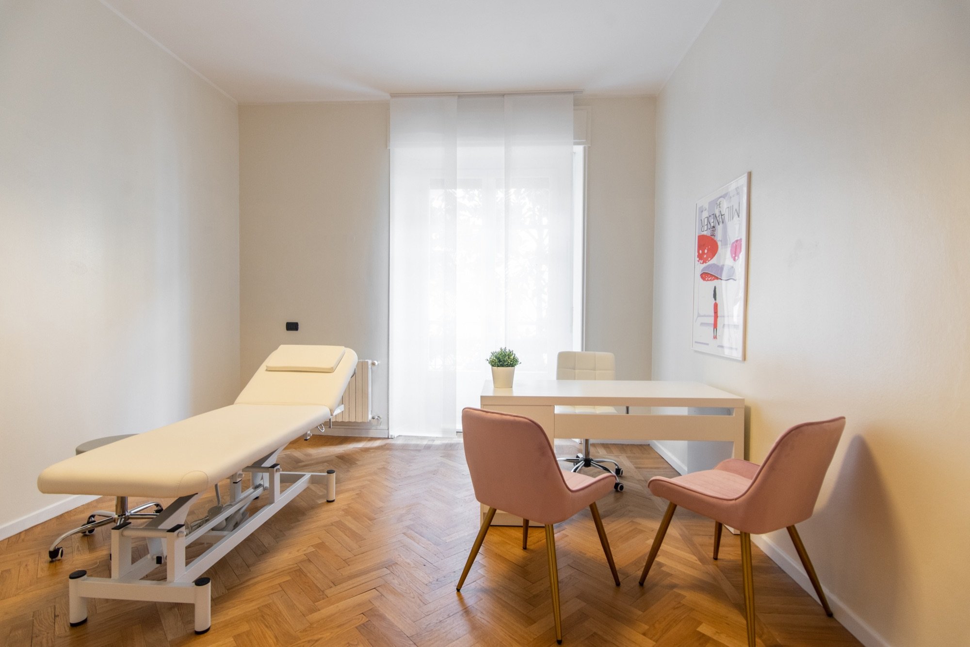 Lettino da visita con tavolo e due poltroncine rosa in studio olistico Lounge presso Spatium Santa Sofia, Milano