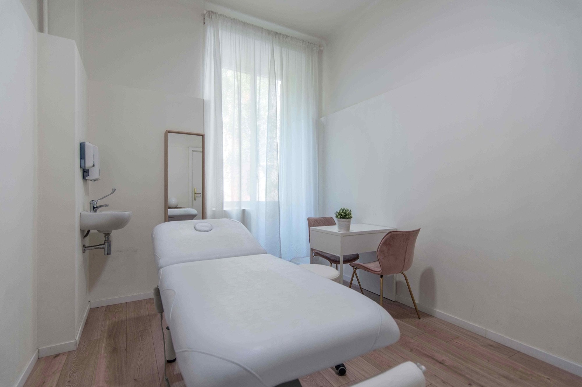 Lettino da visita in primo piano con tavolo laterale in studio olistico Premium presso Spatium Caiazzo, Milano