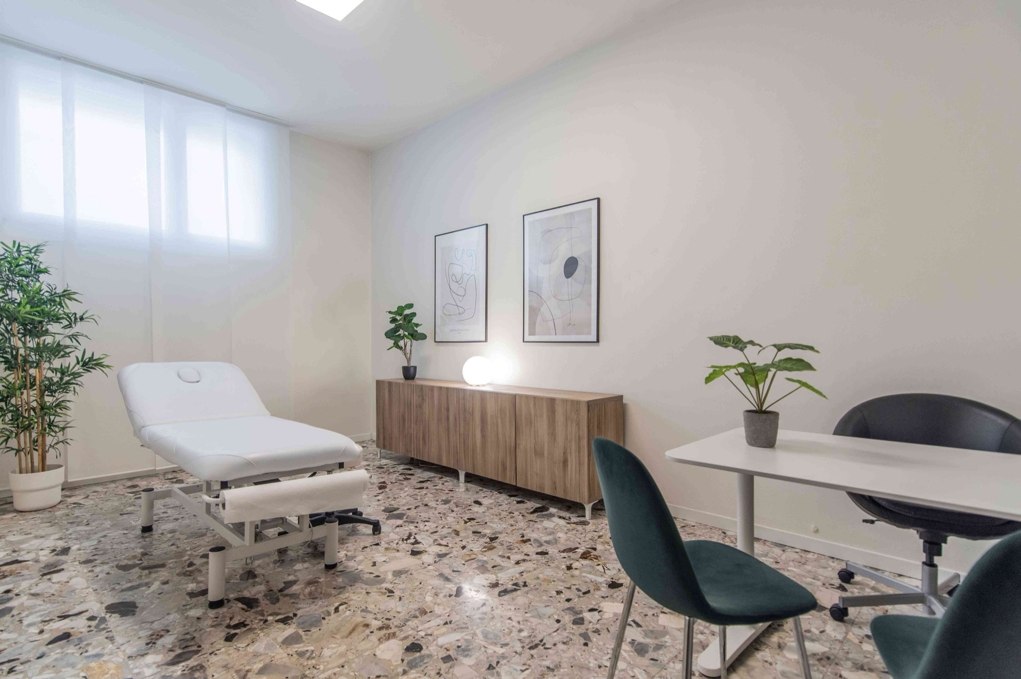 Lettino da visita con tavolo e sedie verdi in studio olistico Exclusive presso Spatium Repubblica, Milano