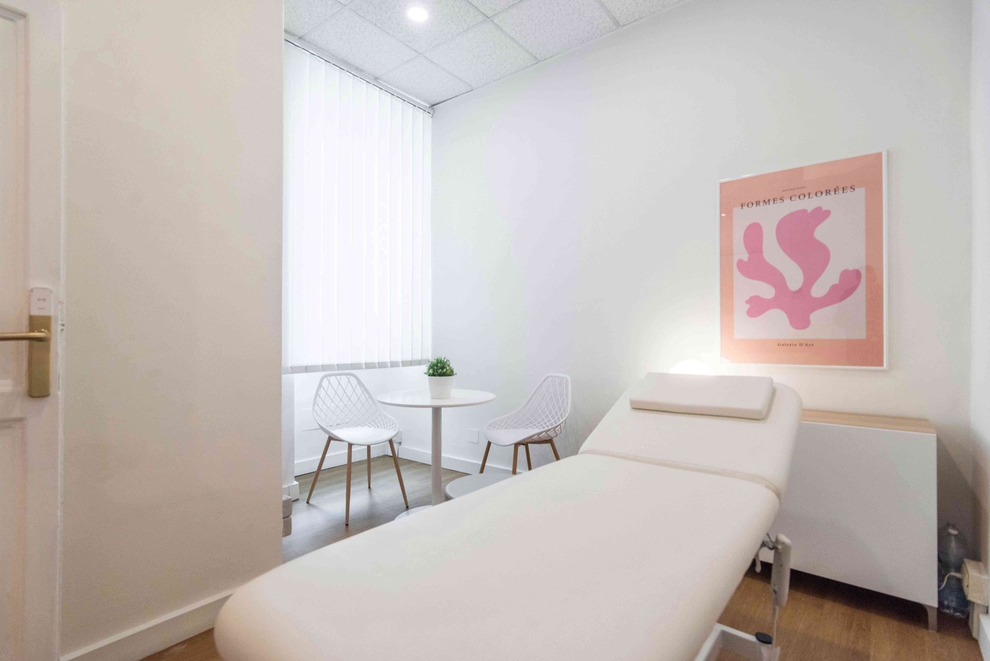 Lettino da visita con tavolino rotondo e sedie bianche in studio olistico Premium presso Spatium Parioli, Roma