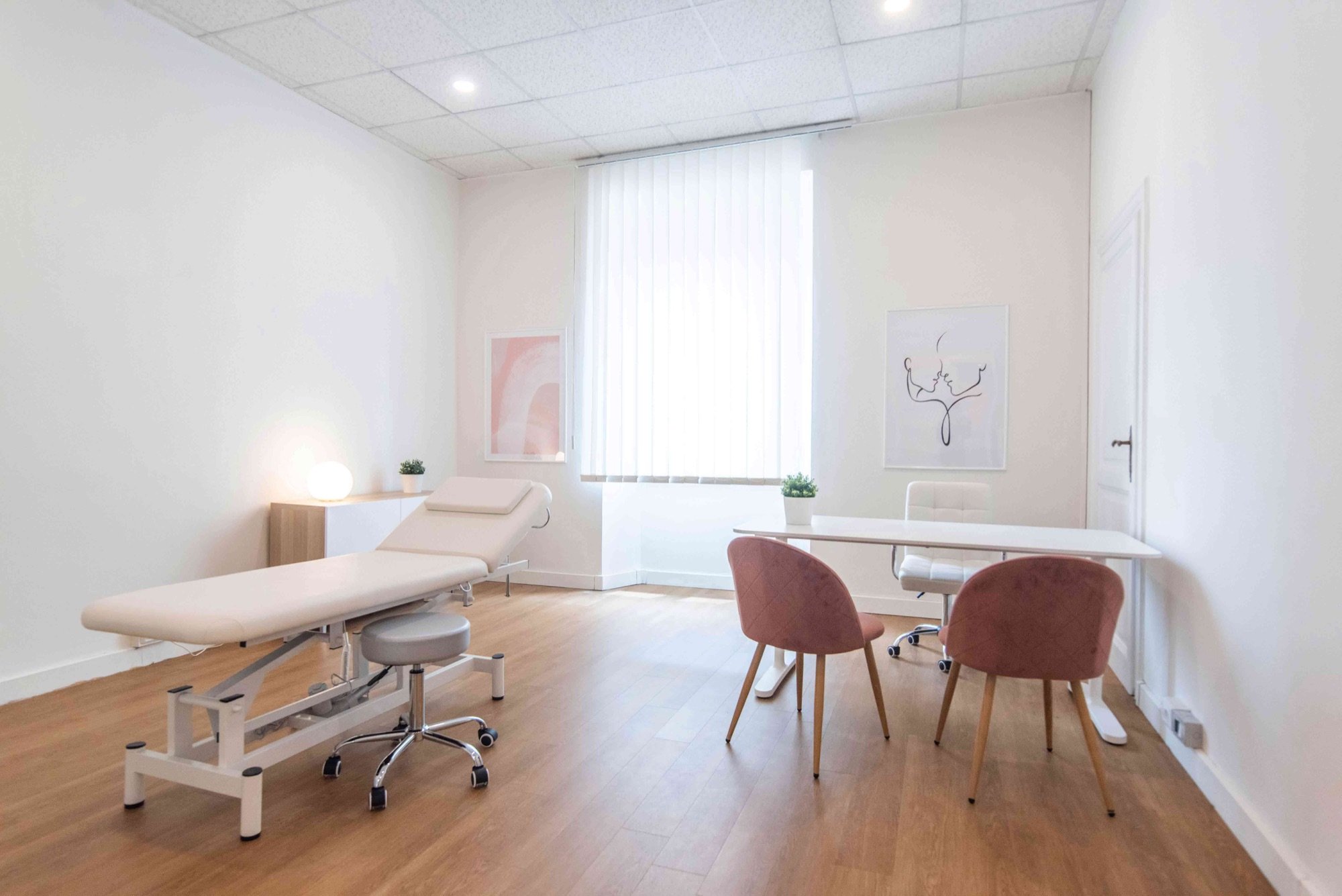 Lettino da visita con tavolo e sedute rosa in studio olistico Lounge presso Spatium Parioli, Roma