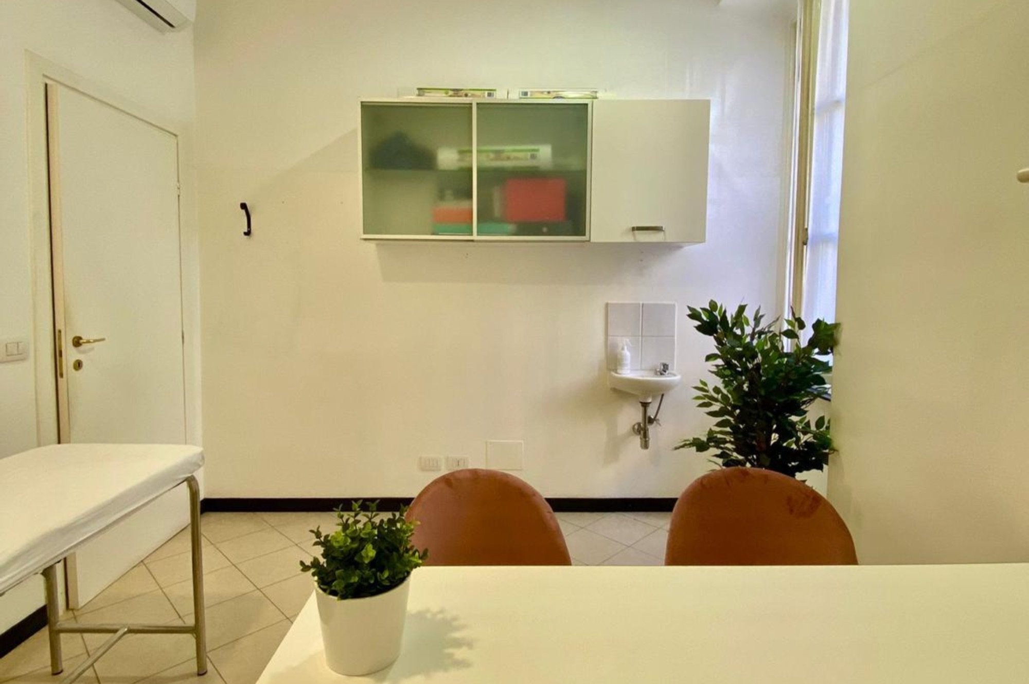 Tavolo colloquio con due sedute e lavabo sullo sfondo in studio professionale Standard presso Spatium Sestri, Genova