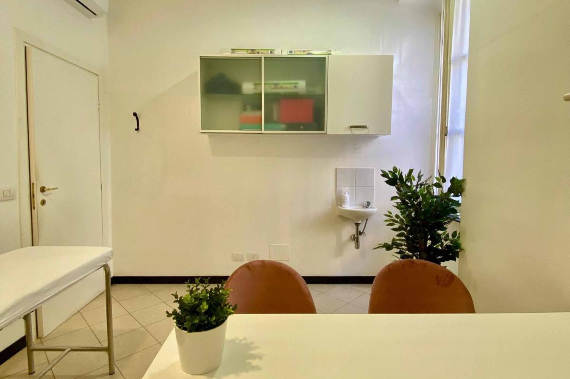 Tavolo colloquio con sedute e lavabo sullo sfondo in studio professionale Standard presso Spatium Righi, Genova