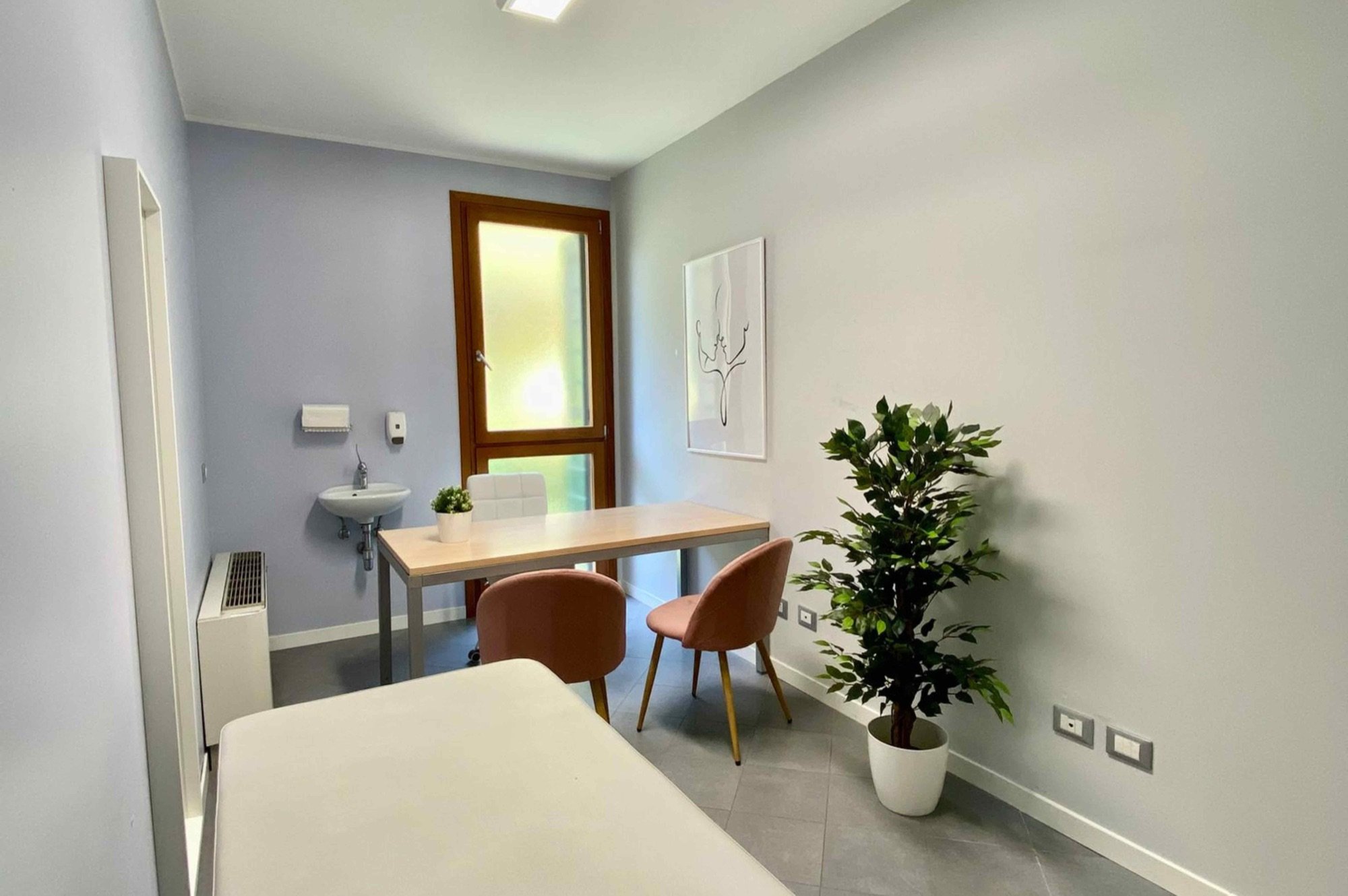 Tavolo colloquio con sedute e lettino in primo piano in studio professionale Top presso Spatium San Donà, Mestre