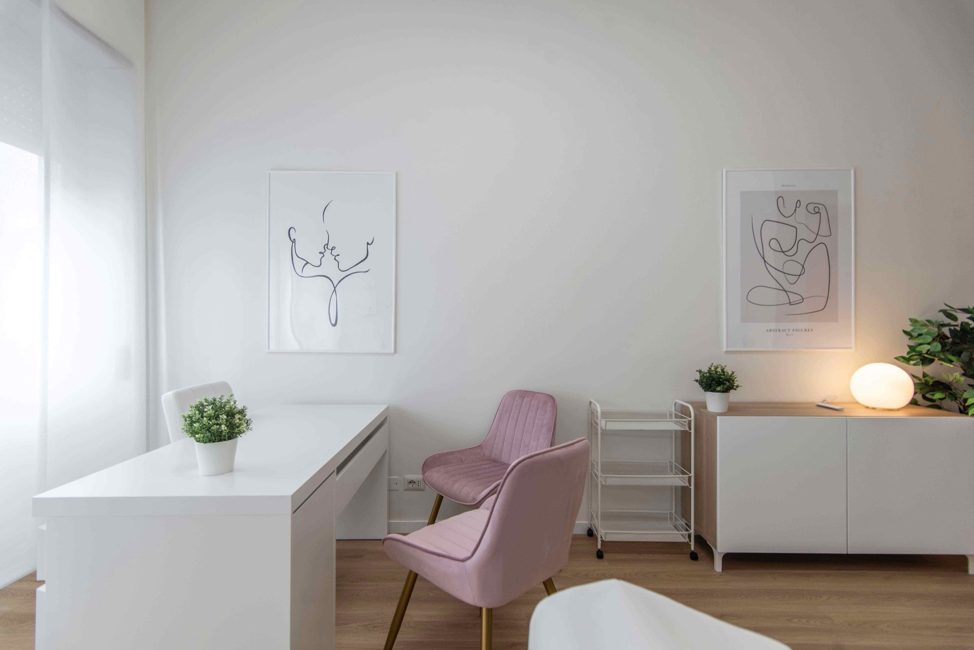 Area colloquio con poltroncine rosa e mobile in studio professionale Exclusive presso Spatium Vittor Pisani, Milano