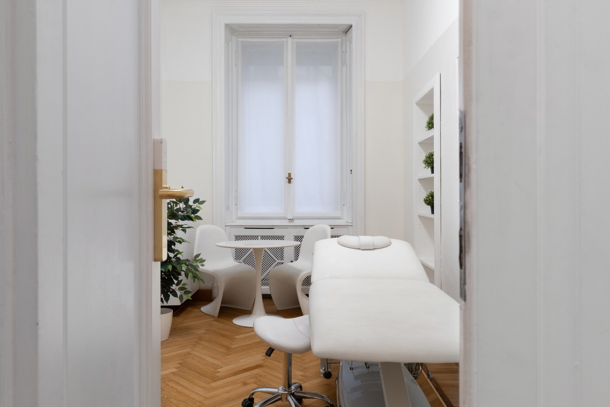 Vista dall'ingresso con lettino e tavolino rotondo in studio professionale Premium presso Spatium Palestro, Milano