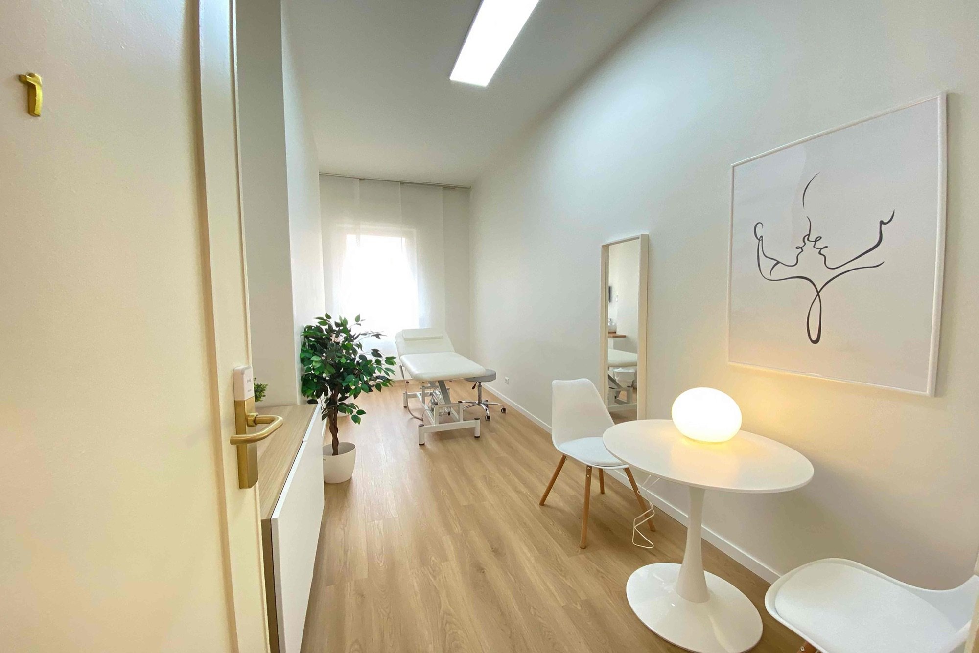 Vista dall'ingresso con tavolo colloquio e lettino sullo sfondo in studio professionale Premium presso Spatium Vittor Pisani, Milano