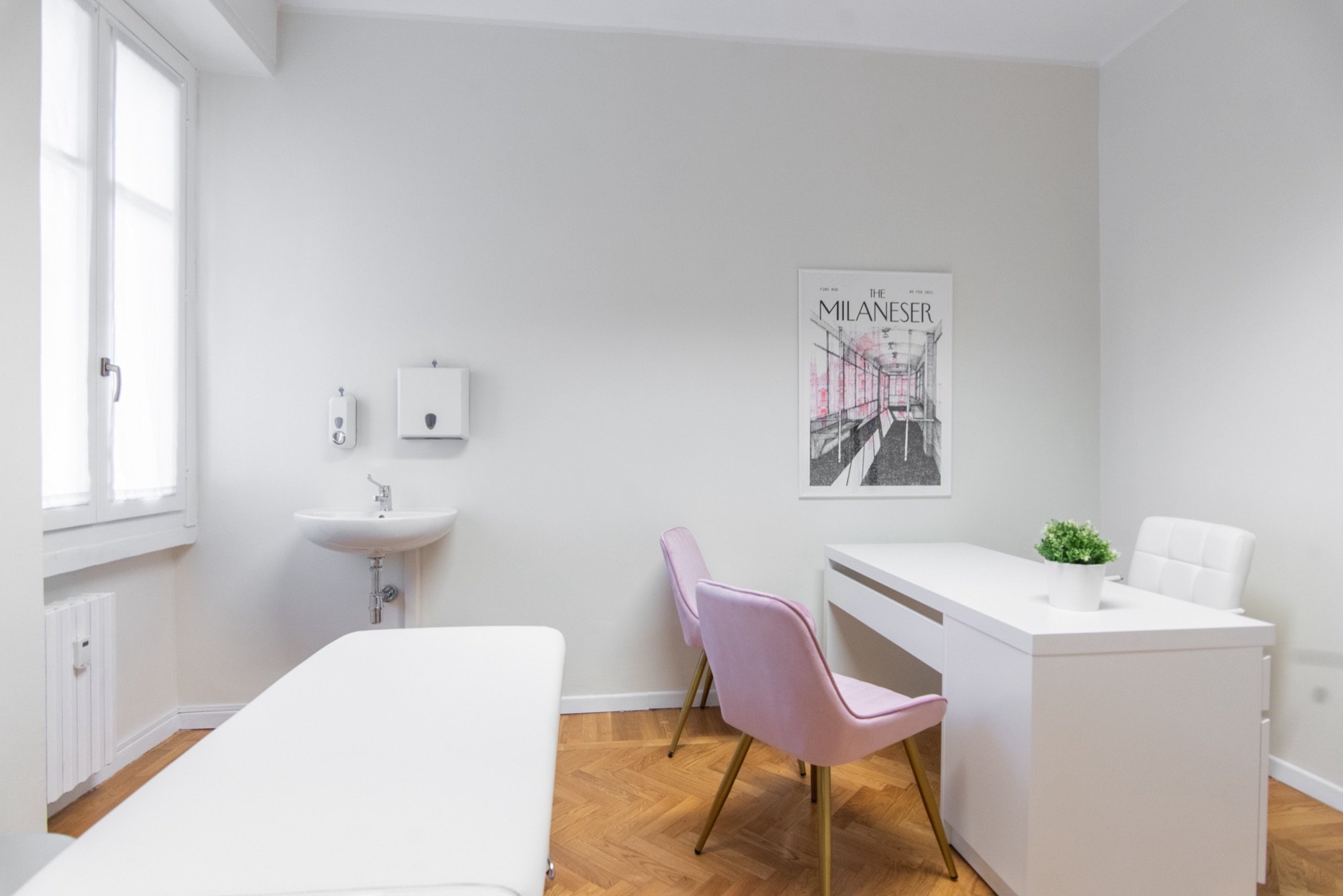 Lavabo clinico con scrivania, sedute rosa e lettino in studio professionale Exclusive presso Spatium Santa Sofia, Milano