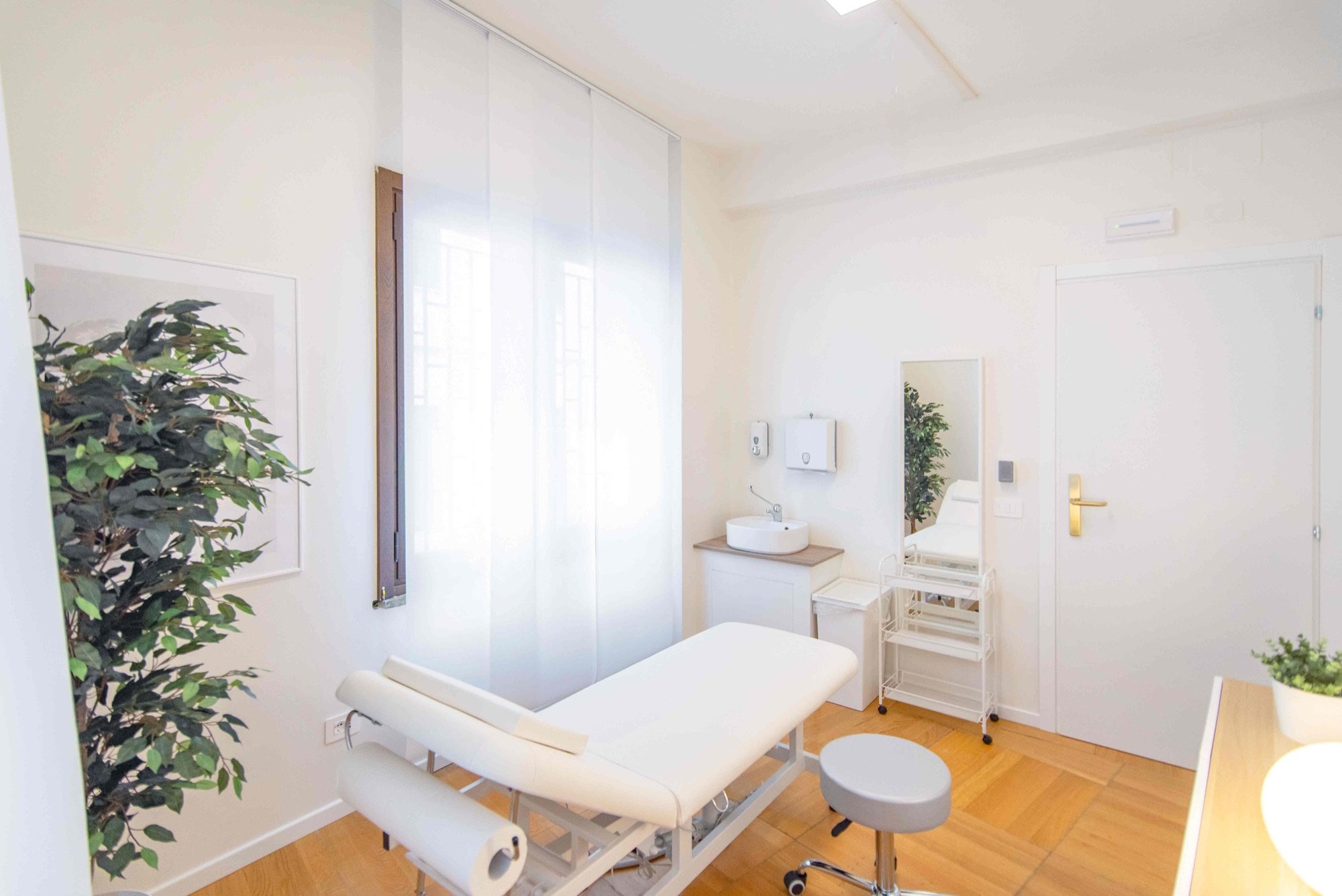 Lettino da visita in vista diagonale con specchio e lavabo in studio professionale Premium presso Spatium Corso Italia, Milano