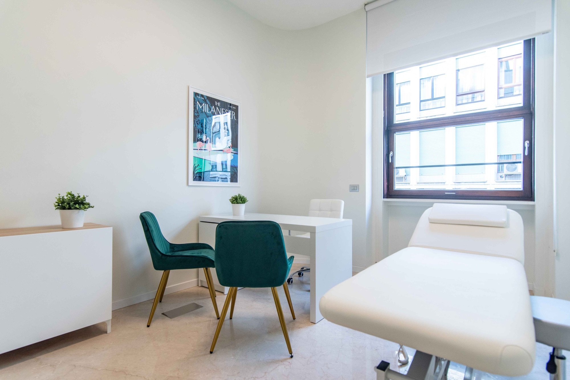 Lettino da visita con due poltroncine verdi vicino alla finestra in studio professionale Exclusive presso Spatium Duomo, Milano