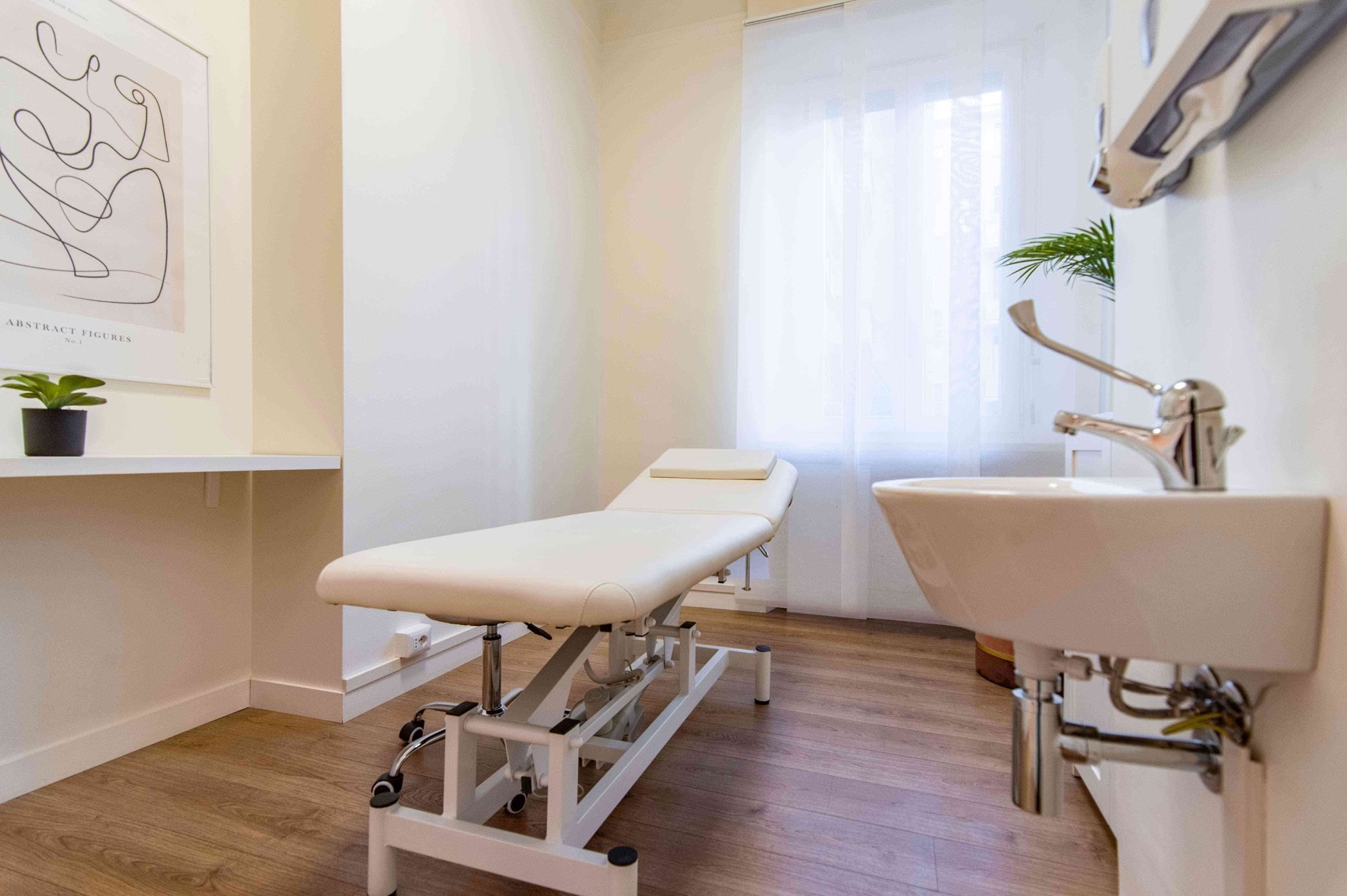 Lettino da visita vicino alla finestra con lavabo in studio professionale Standard presso Spatium Policlinico, Milano