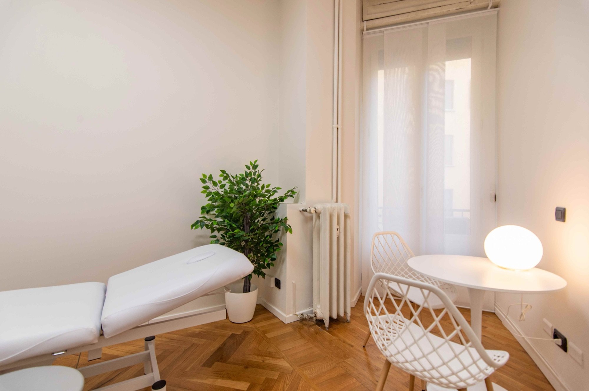 Lettino da visita vicino alla finestra con tavolino in studio professionale Premium presso Spatium Cinque Giornate, Milano