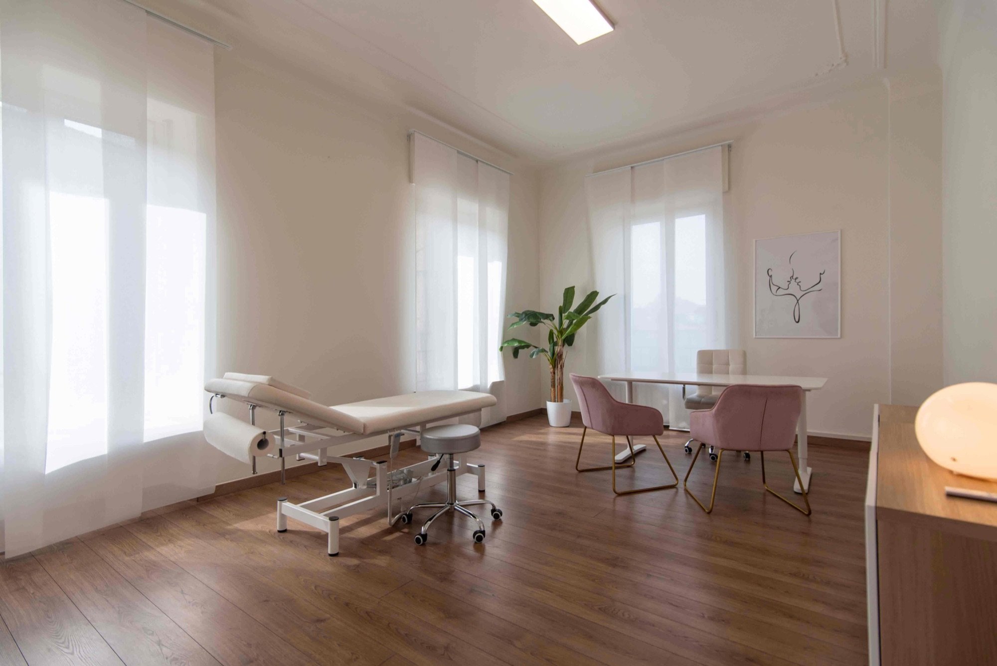 Lettino da visita vicino alle finestre con tavolo colloquio in studio professionale Lounge presso Spatium Policlinico, Milano