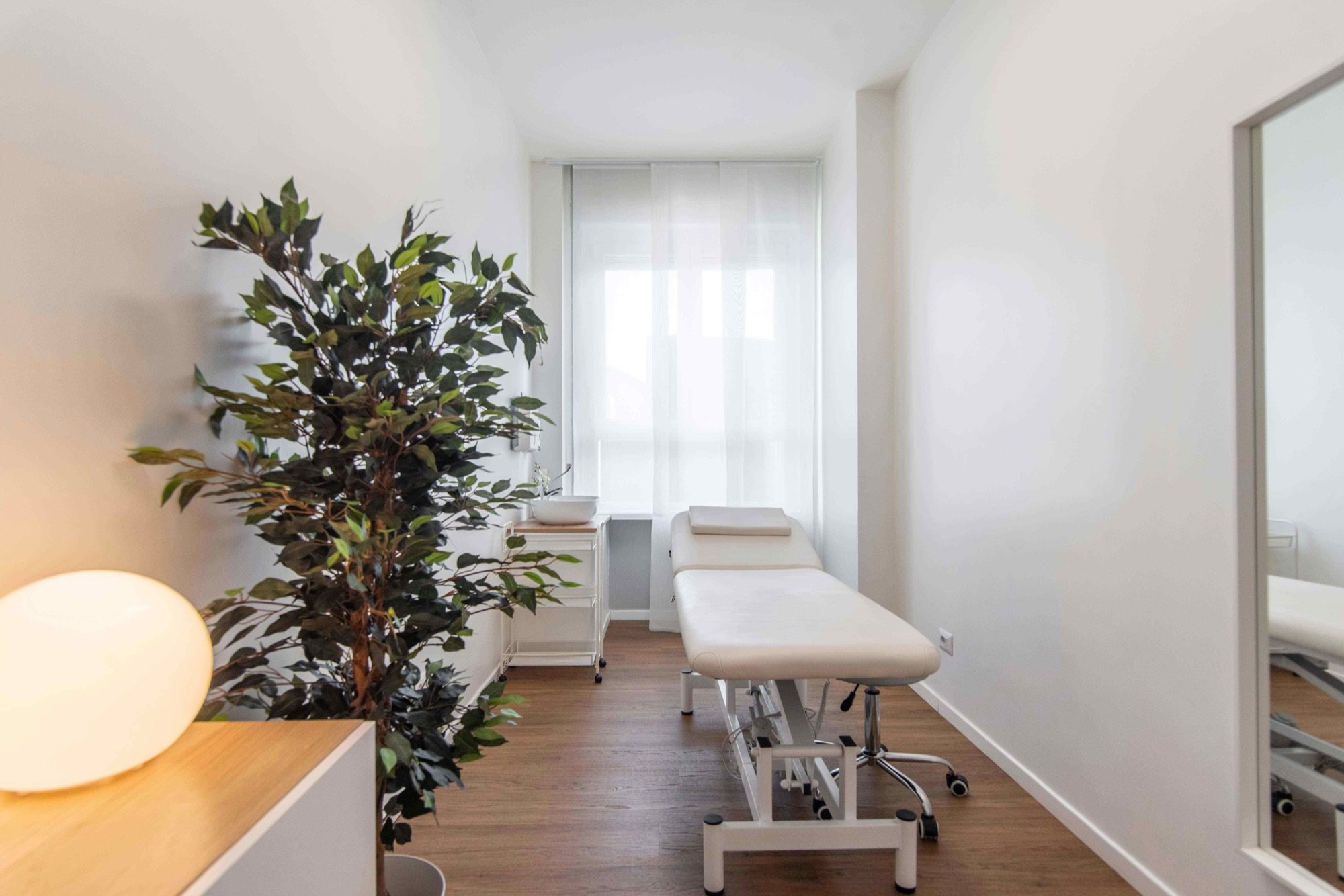 Lettino da visita con grande pianta e finestra in studio professionale Standard presso Spatium Porta Romana, Milano