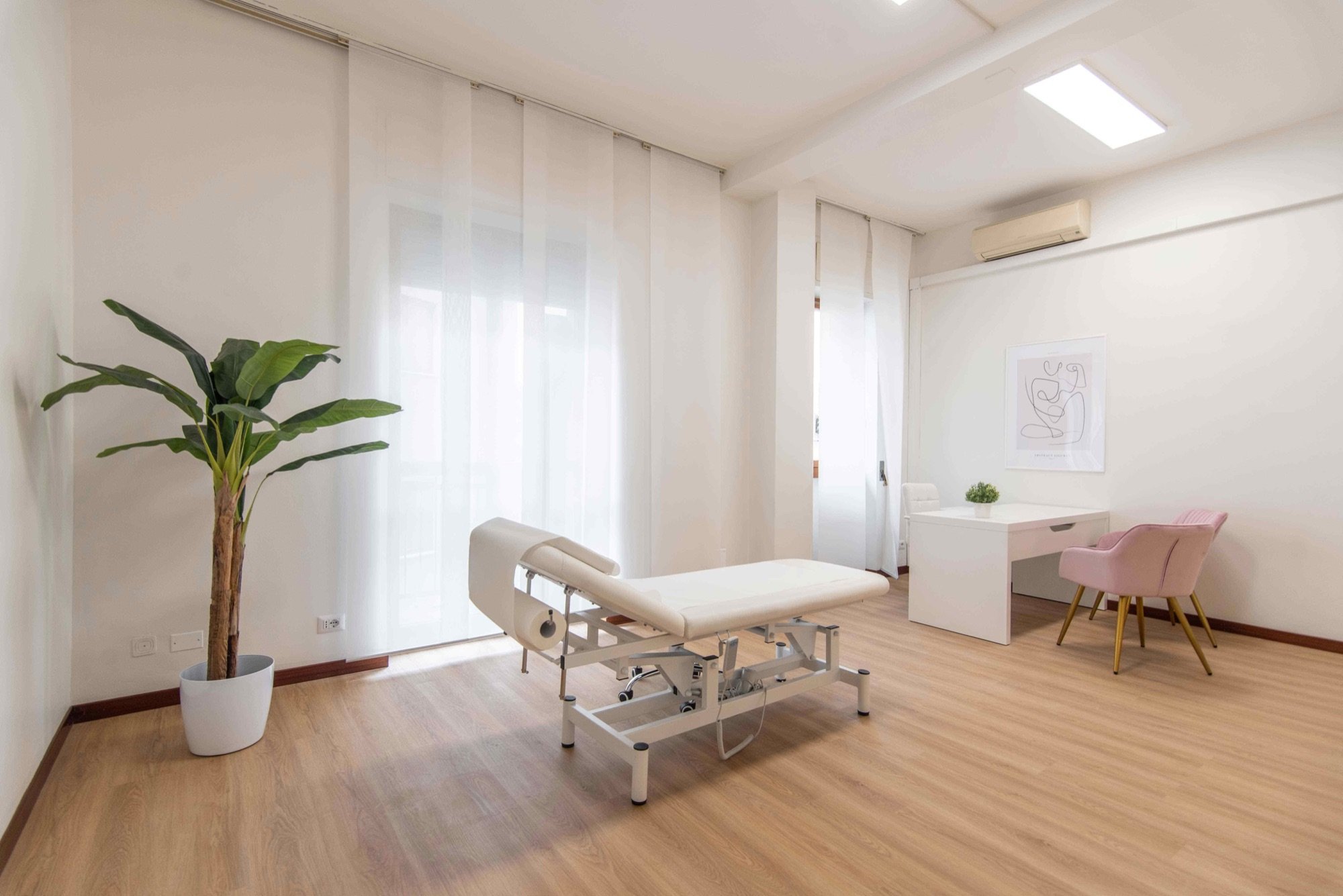 Lettino da visita con grande pianta e finestre in studio professionale Lounge presso Spatium Vittor Pisani, Milano
