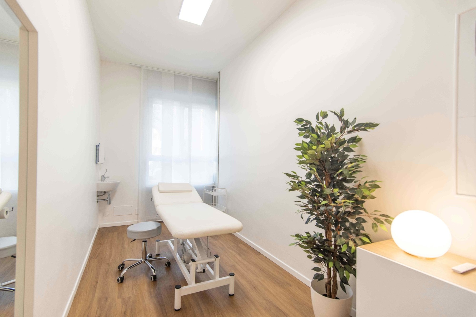 Lettino da visita con grande pianta e lampada in studio professionale Standard presso Spatium Porta Romana, Milano