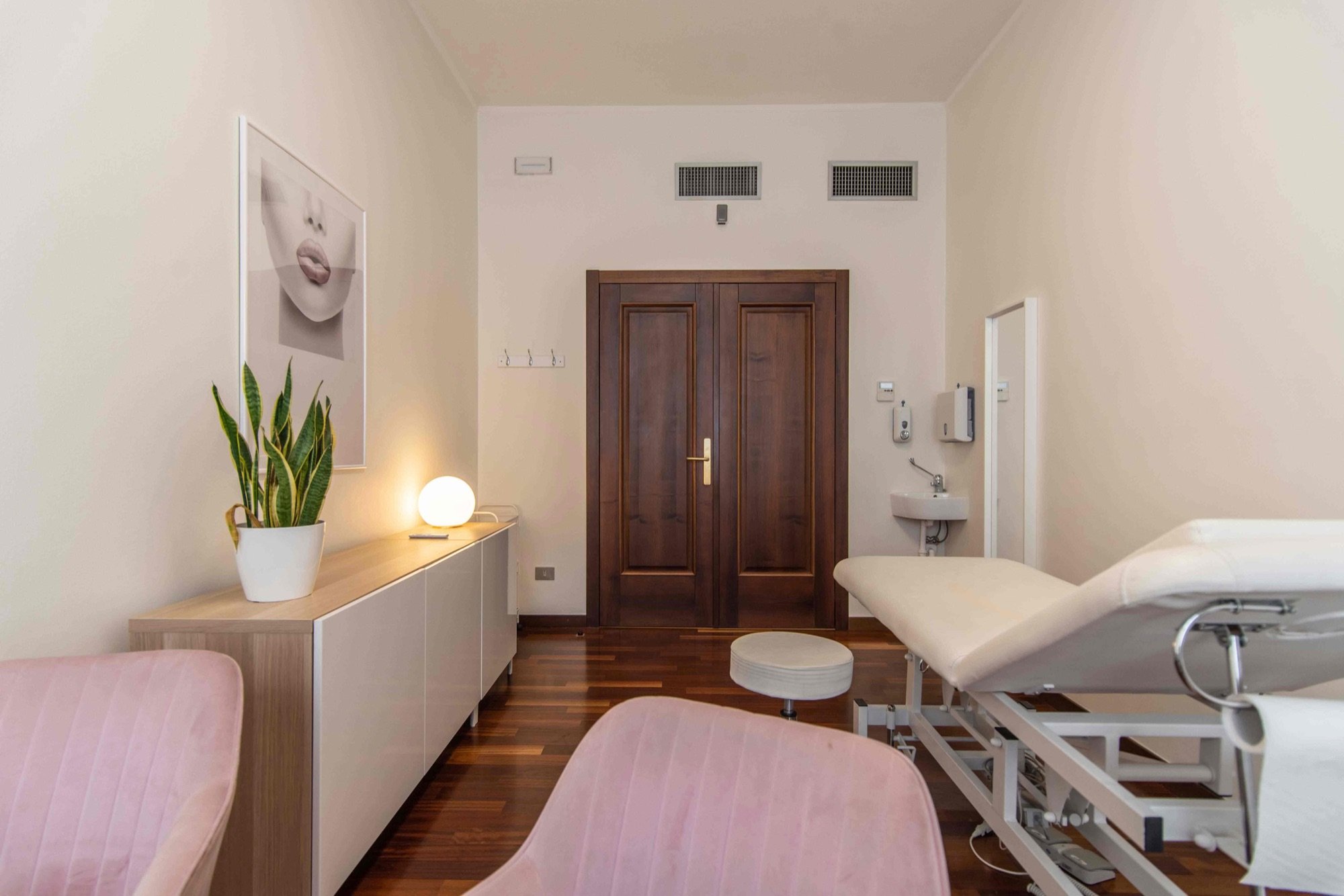 Lettino da visita con lavabo e poltroncine rosa in studio professionale Exclusive presso Spatium Duomo, Milano