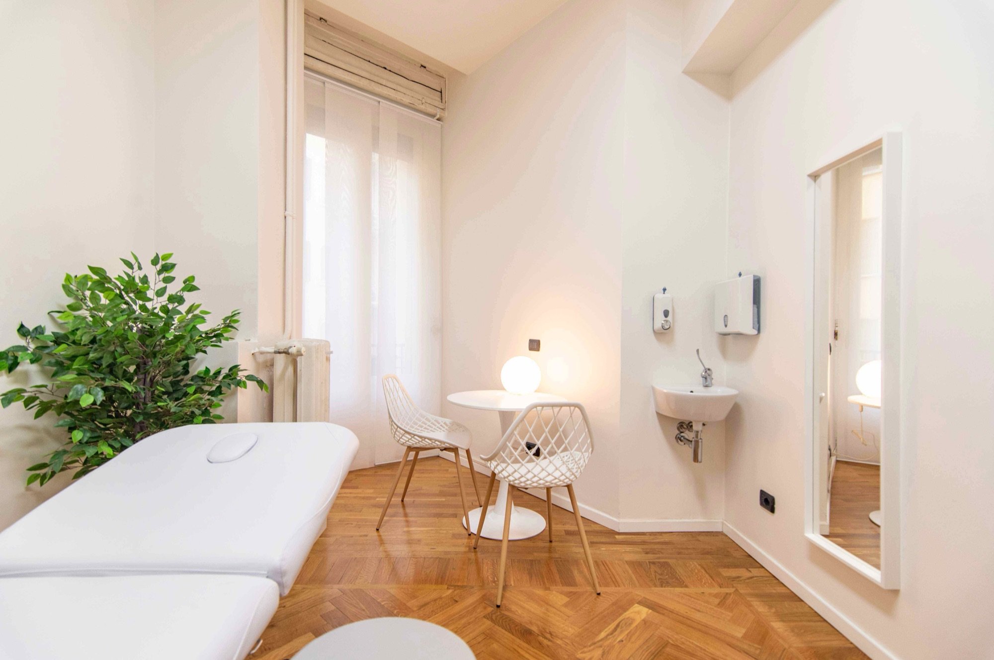 Lettino da visita in primo piano con lavabo e sedute in studio professionale Premium presso Spatium Cinque Giornate, Milano