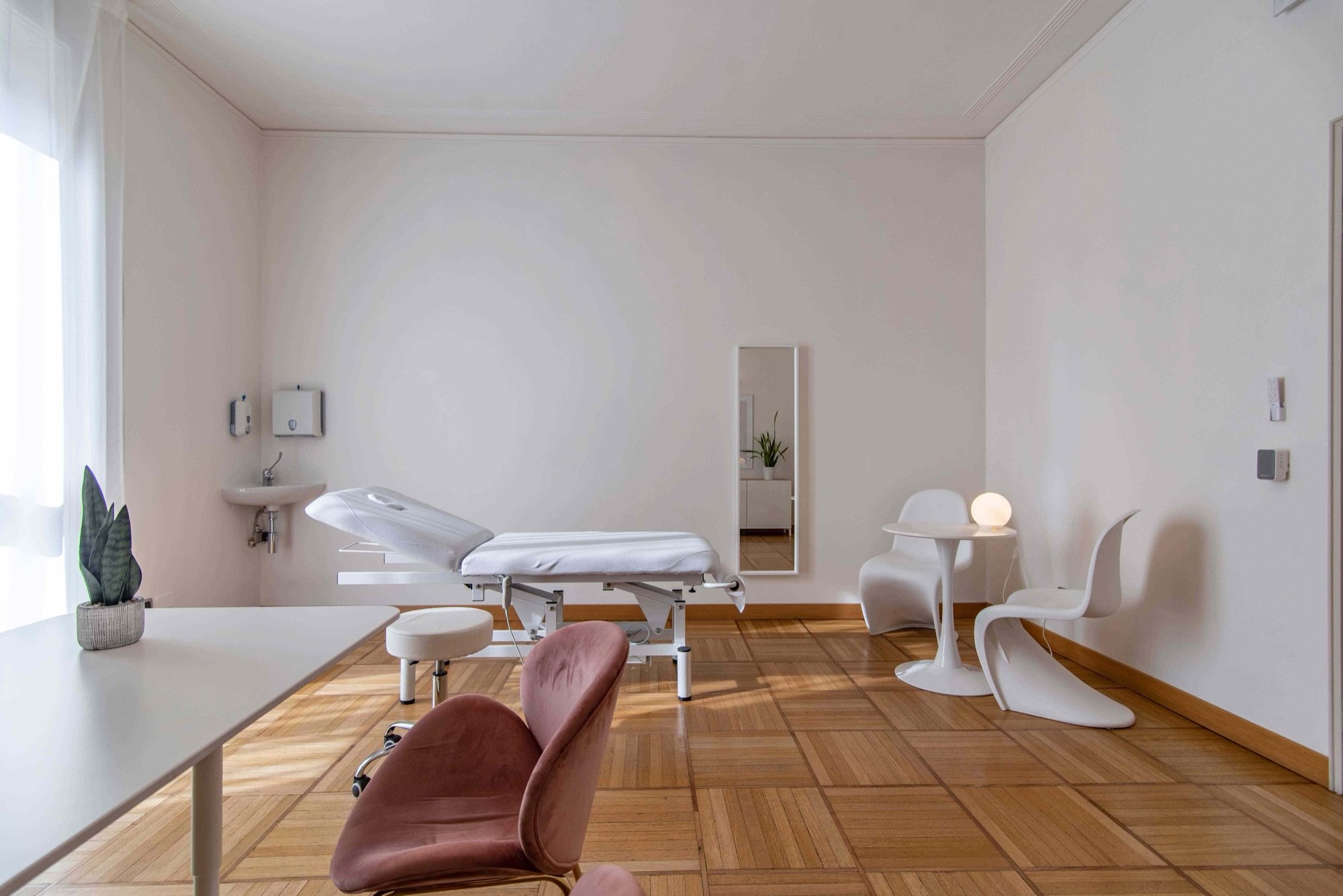Lettino da visita con lavabo e sedute bianche in studio professionale Lounge presso Spatium Missori, Milano