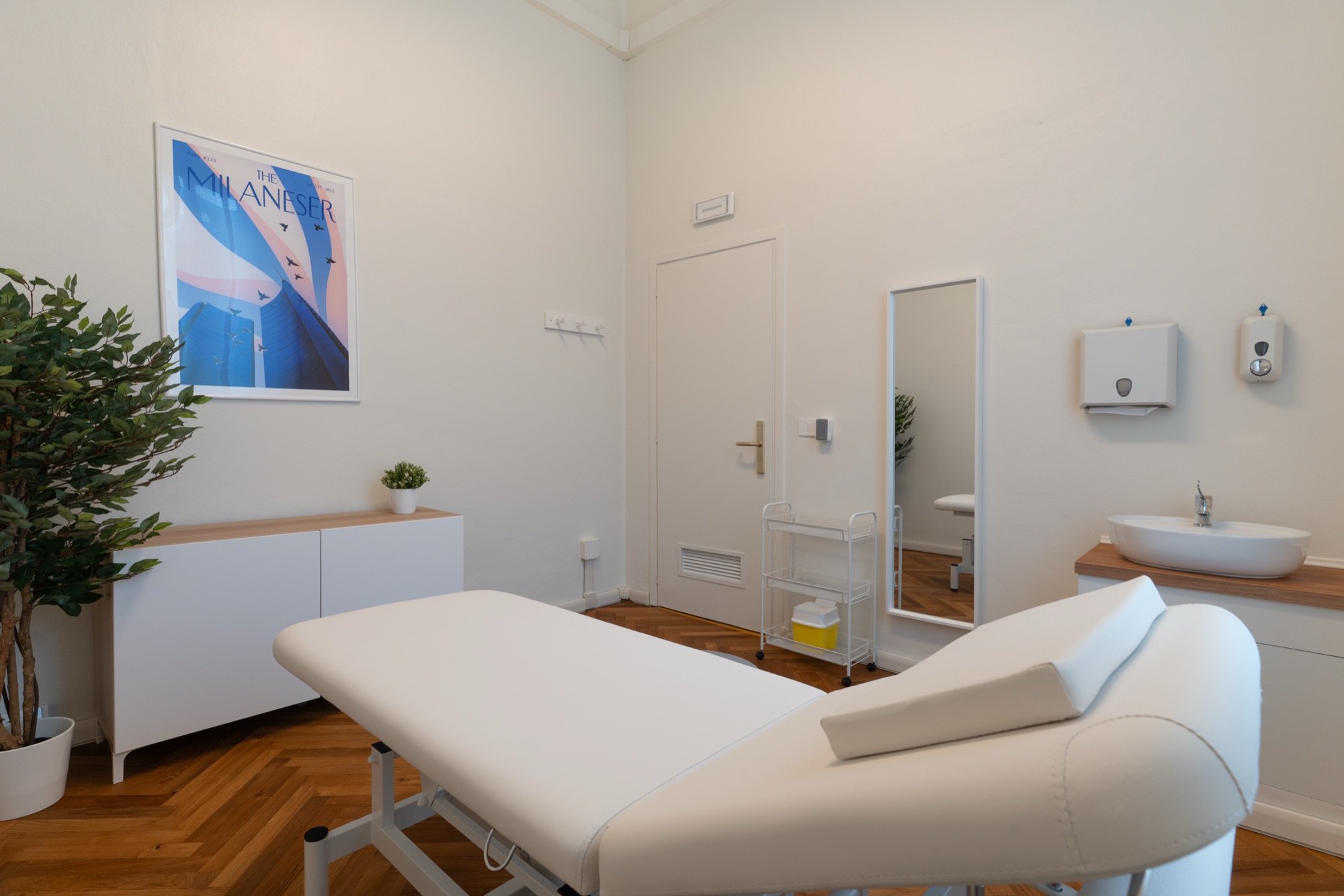 Lettino da visita in primo piano con lavabo e specchio in studio professionale Premium presso Spatium Corso Vercelli, Milano