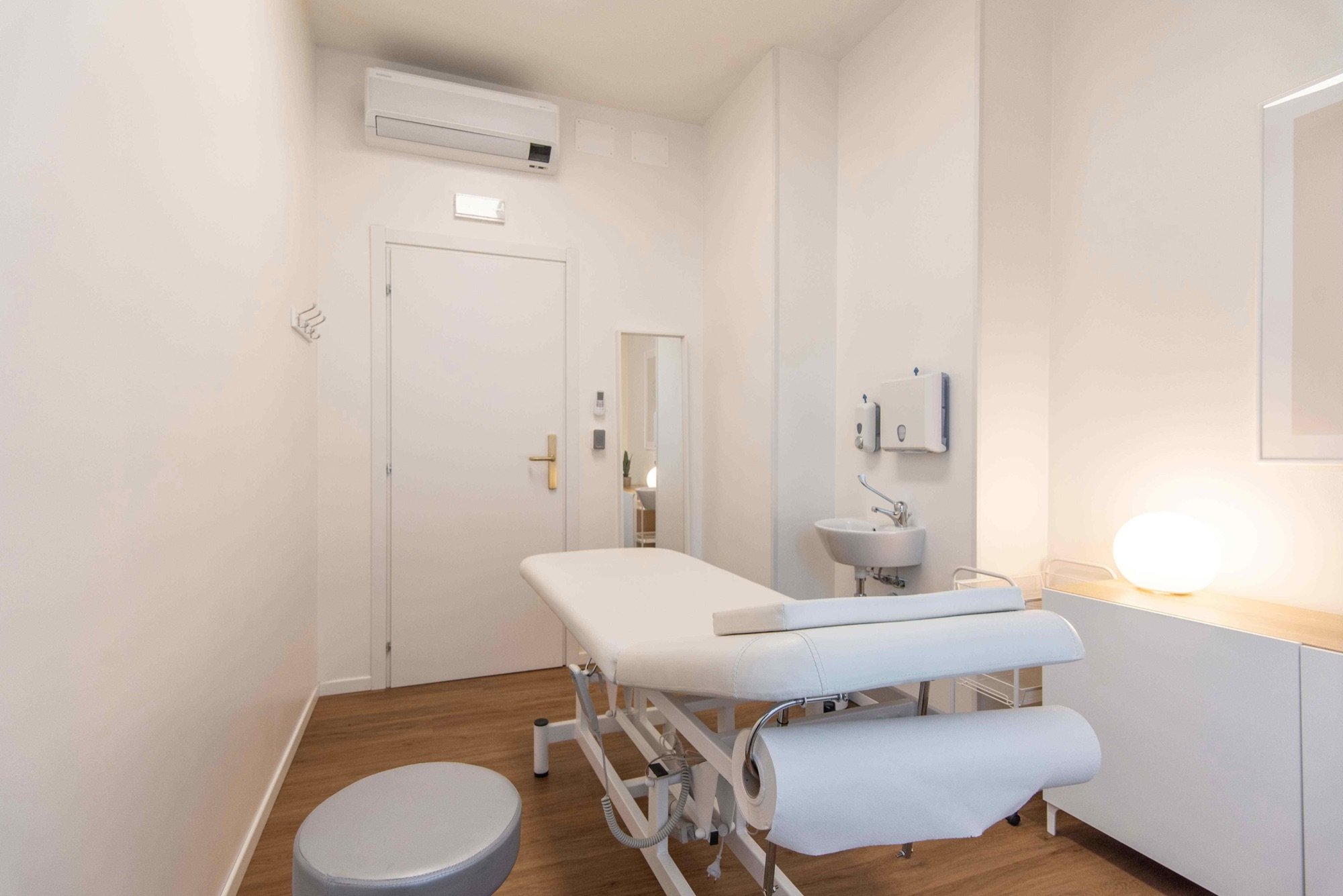 Lettino da visita con lavabo, specchio e lampada in studio professionale Standard presso Spatium Porta Romana, Milano