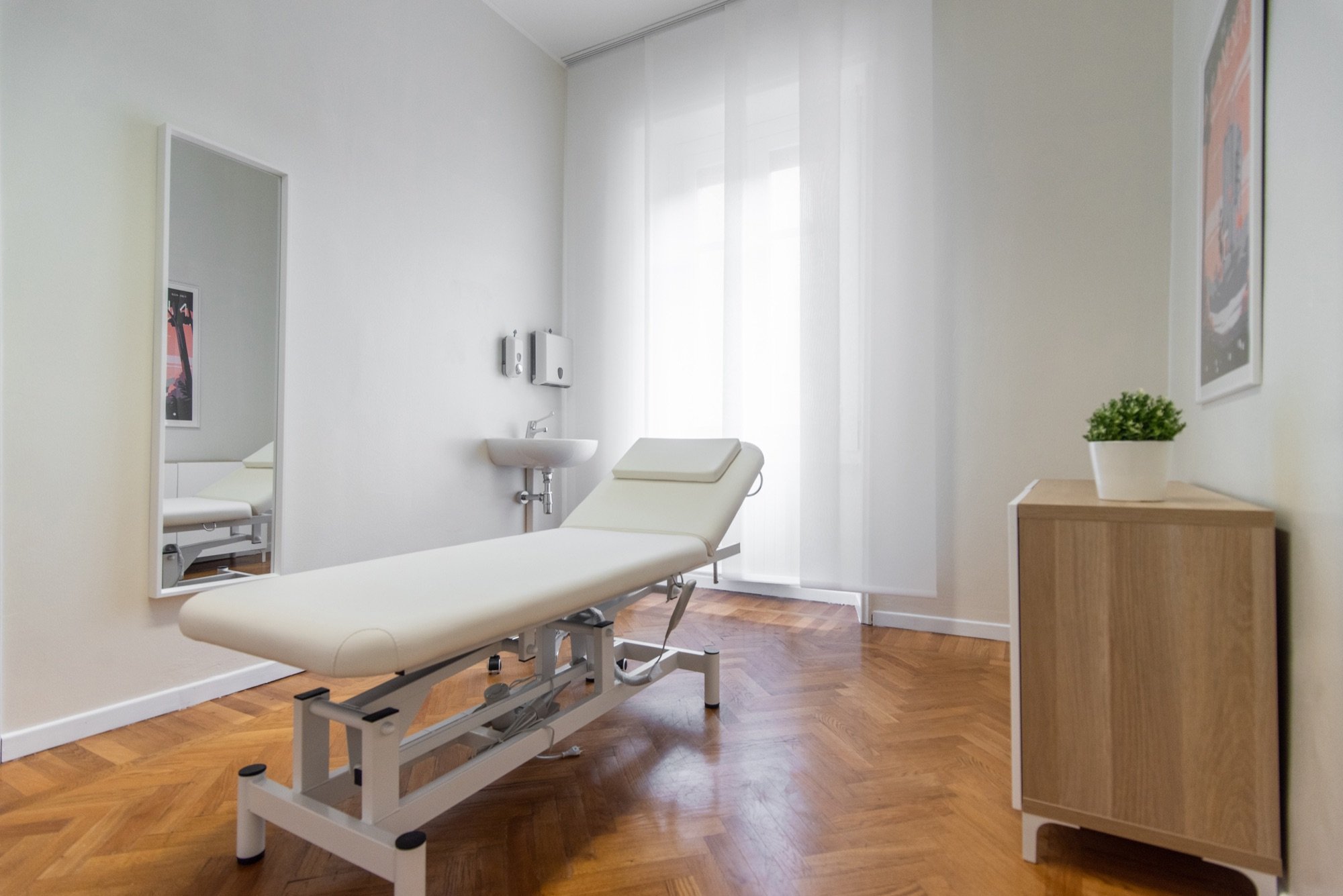 Lettino da visita con mobile in legno e finestra in studio professionale Premium presso Spatium Santa Sofia, Milano