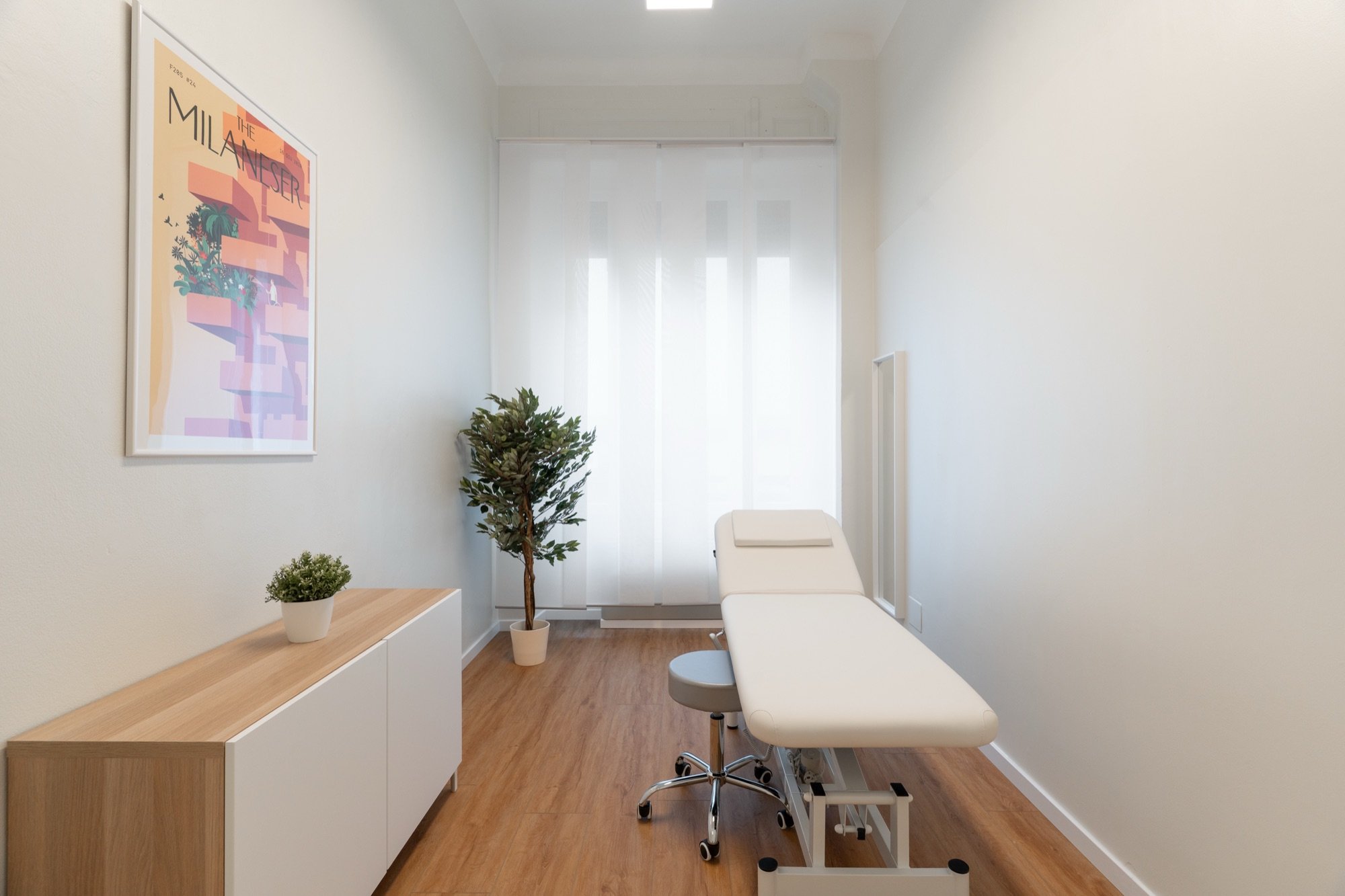 Lettino da visita con mobile in legno, pianta e quadro in studio professionale Premium presso Spatium Corso Vercelli, Milano
