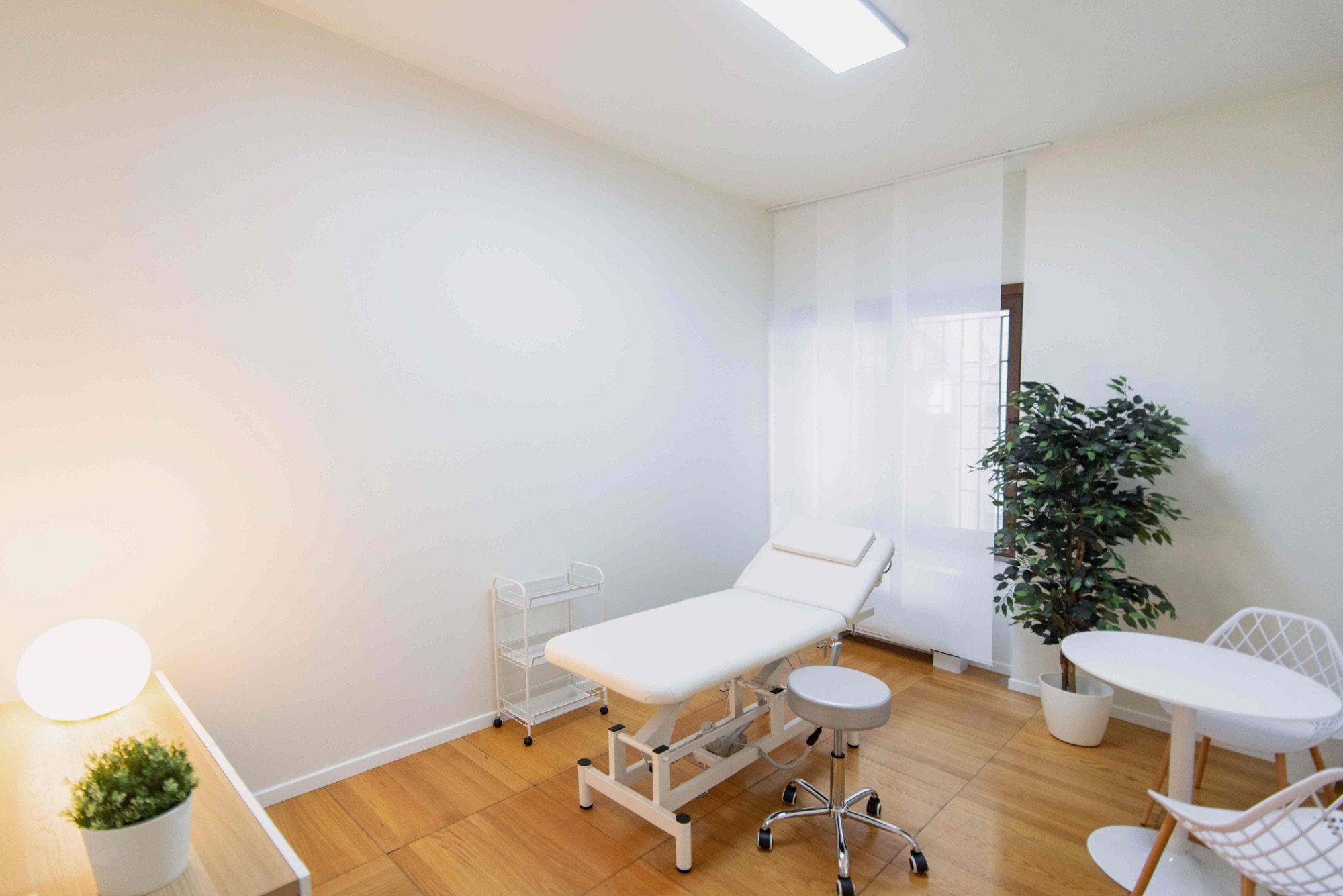 Lettino da visita con pianta e poltroncina in studio professionale Premium presso Spatium Corso Italia, Milano