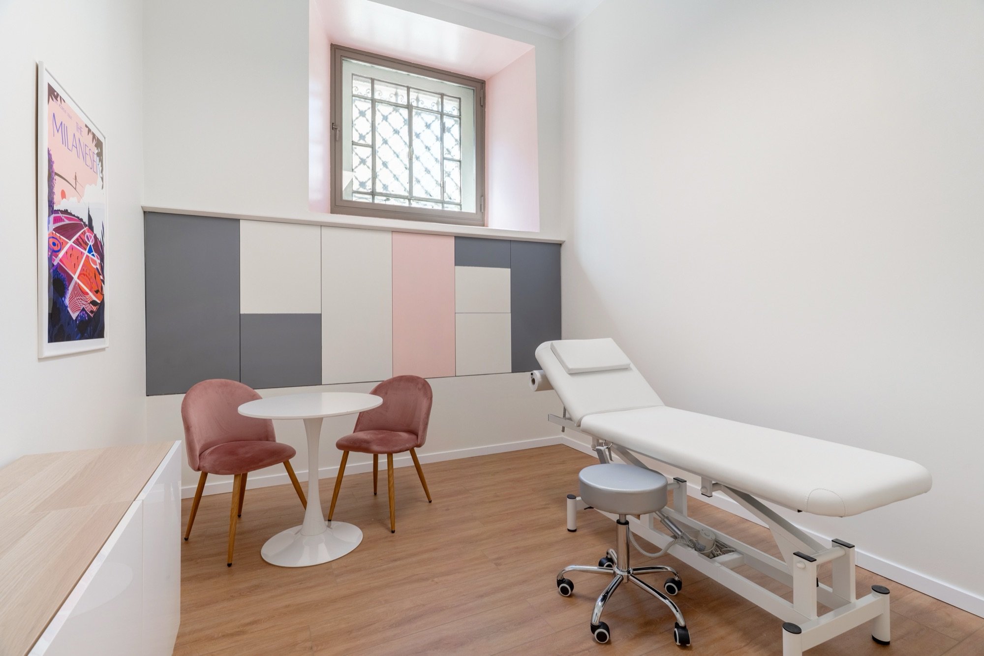 Lettino da visita con poltroncine rosa e mobili contenitori a parete in studio professionale Premium Spatium Corso Vercelli, Milano