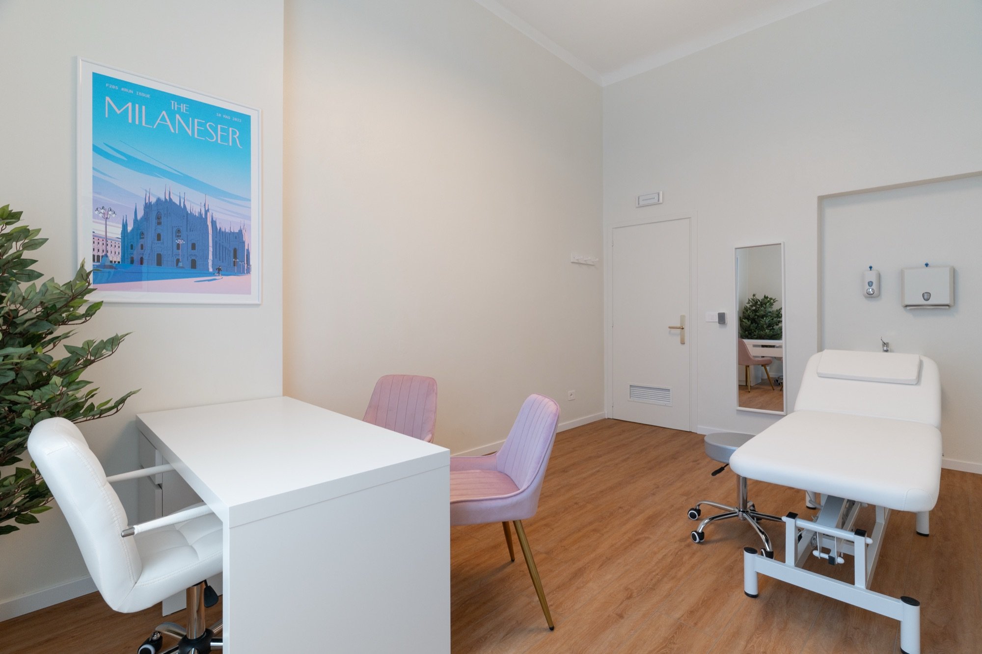 Lettino da visita con scrivania, sedute rosa e lavabo in studio professionale Exclusive presso Spatium Corso Vercelli, Milano