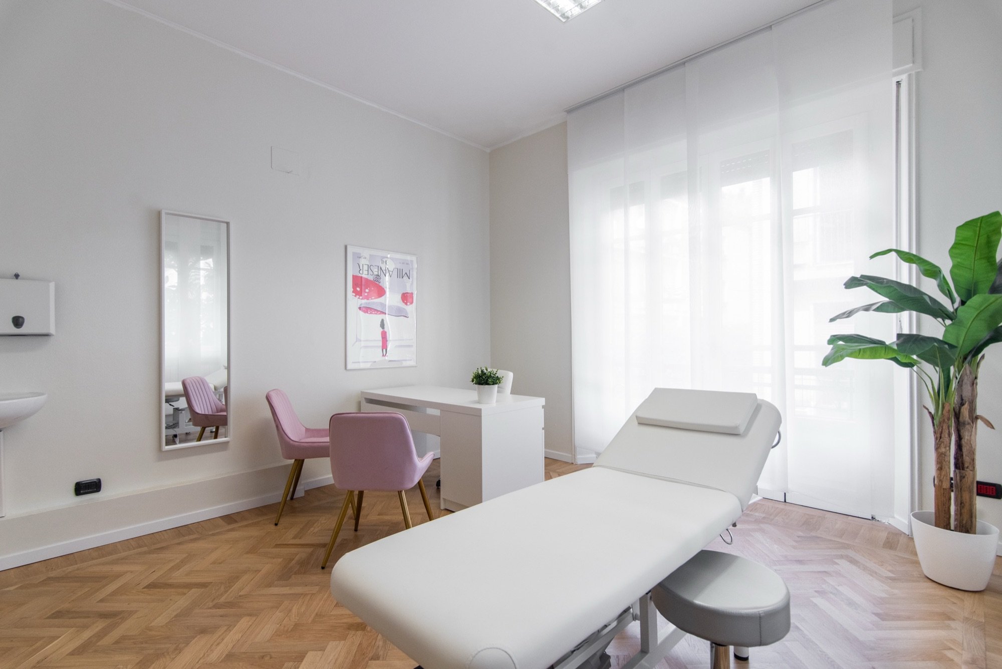 Lettino da visita in primo piano con seduta rosa e pianta in studio professionale Lounge presso Spatium Santa Sofia, Milano