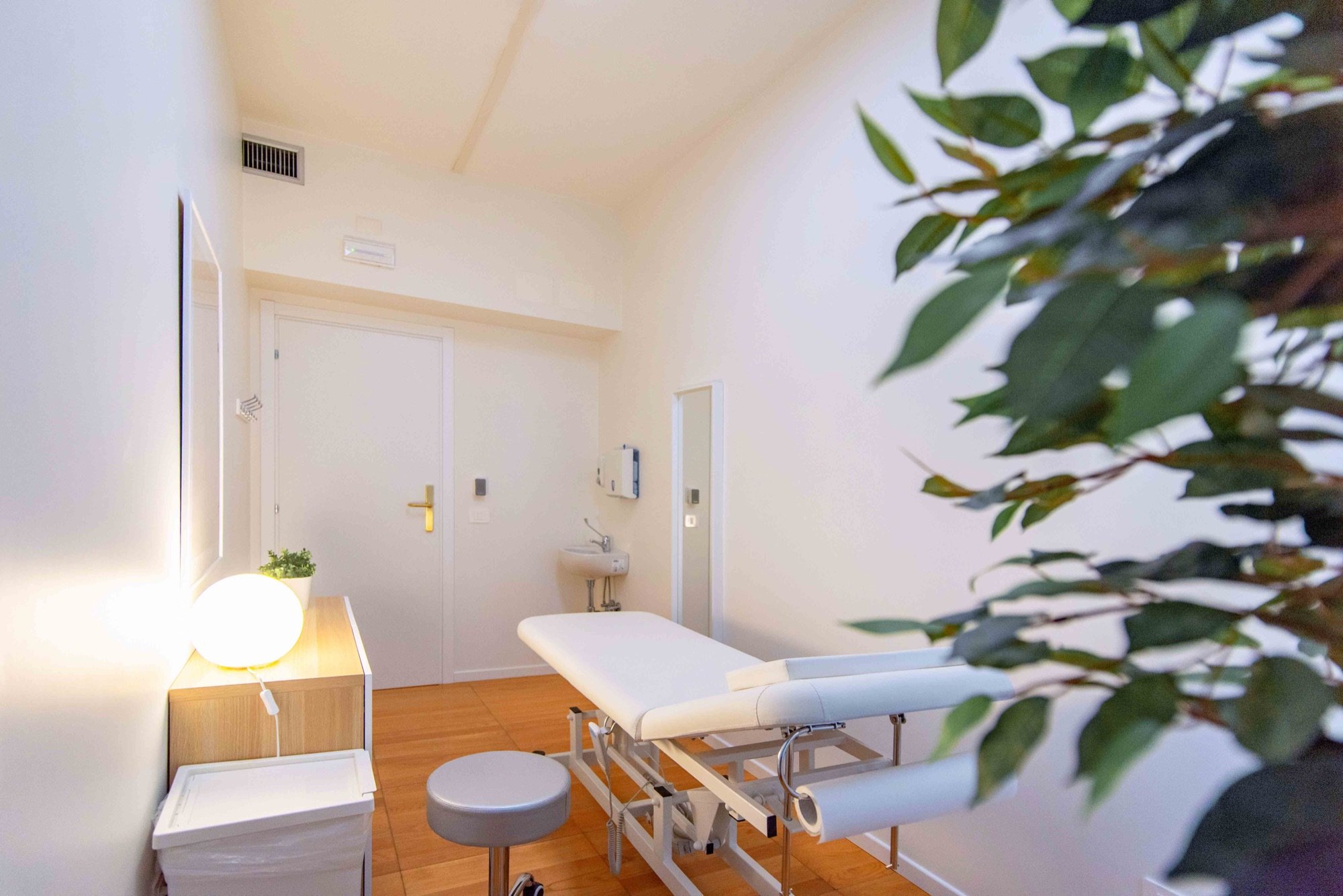 Lettino da visita con sgabello, lavabo e pianta in studio professionale Standard presso Spatium Corso Italia, Milano