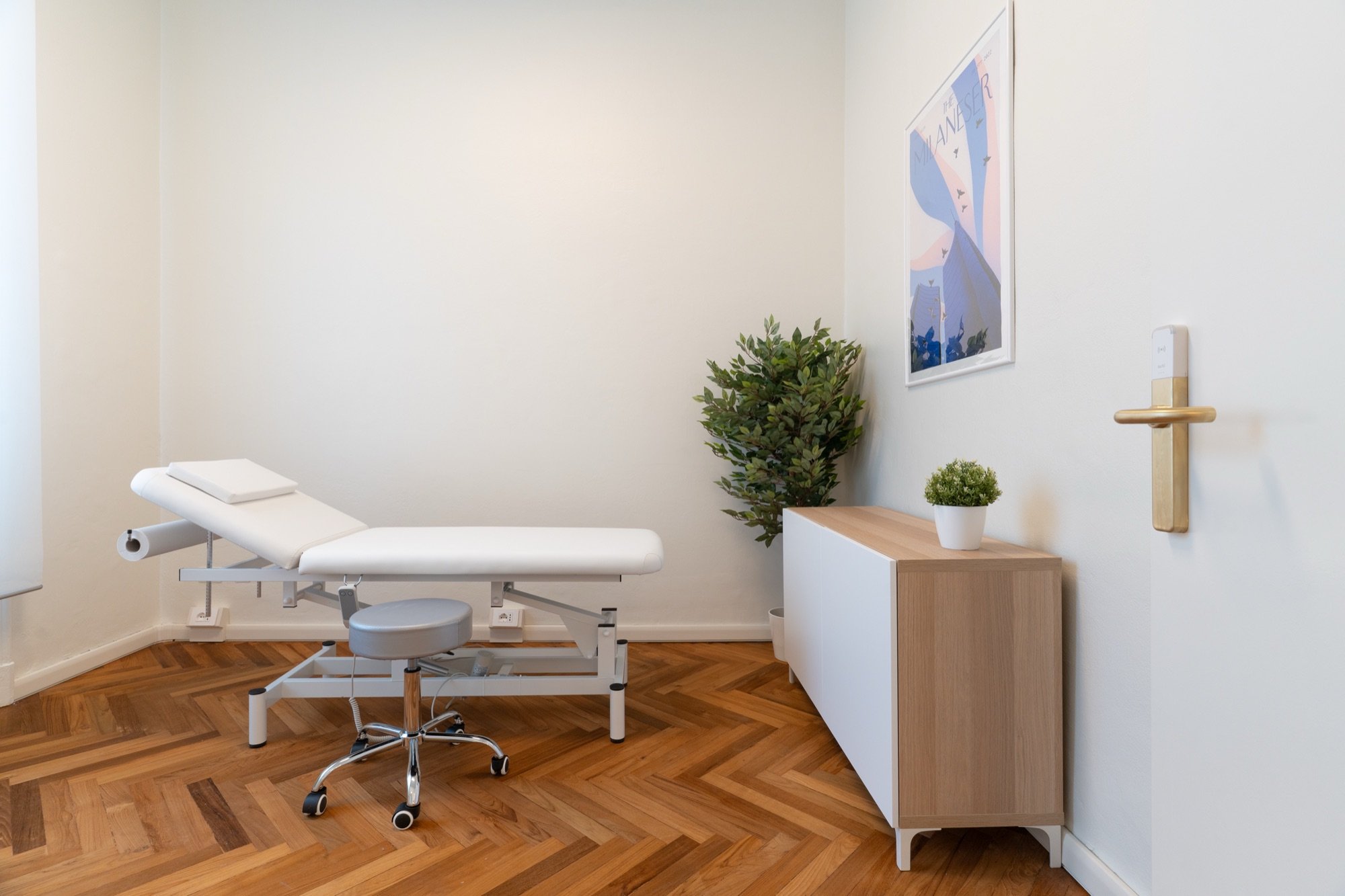 Lettino da visita con sgabello, mobile e grande pianta in studio professionale Premium presso Spatium Corso Vercelli, Milano