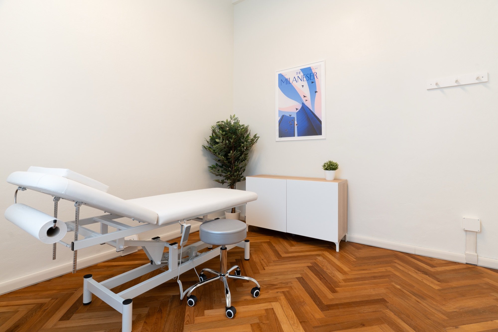 Lettino da visita con sgabello, mobile e quadro blu in studio professionale Standard presso Spatium Corso Vercelli, Milano