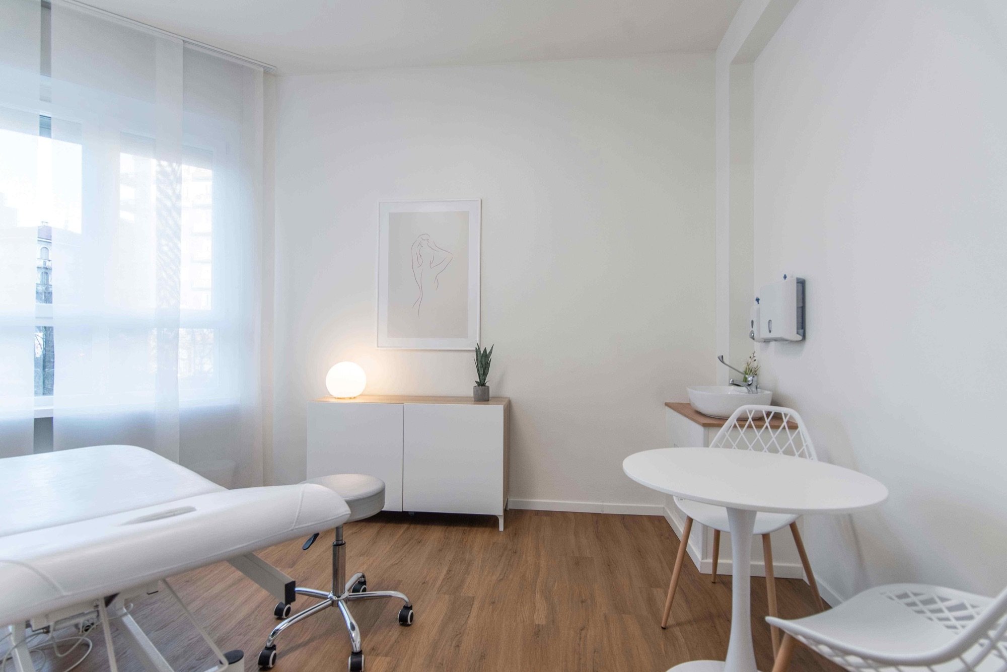 Lettino da visita con tavolino rotondo vicino alla finestra in studio professionale Premium presso Spatium Porta Romana, Milano