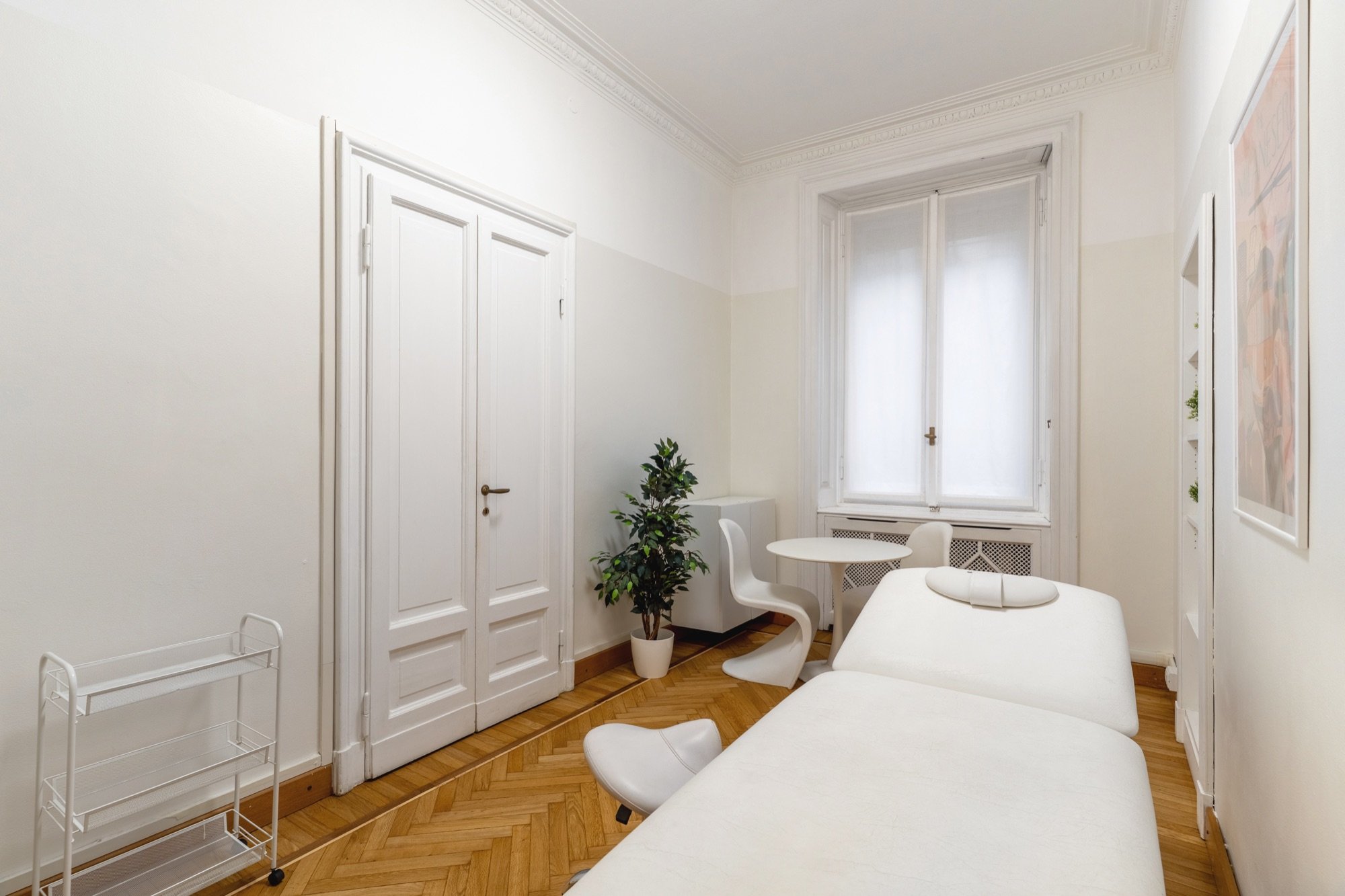 Lettino da visita con tavolino rotondo e pianta in studio professionale Premium presso Spatium Palestro, Milano