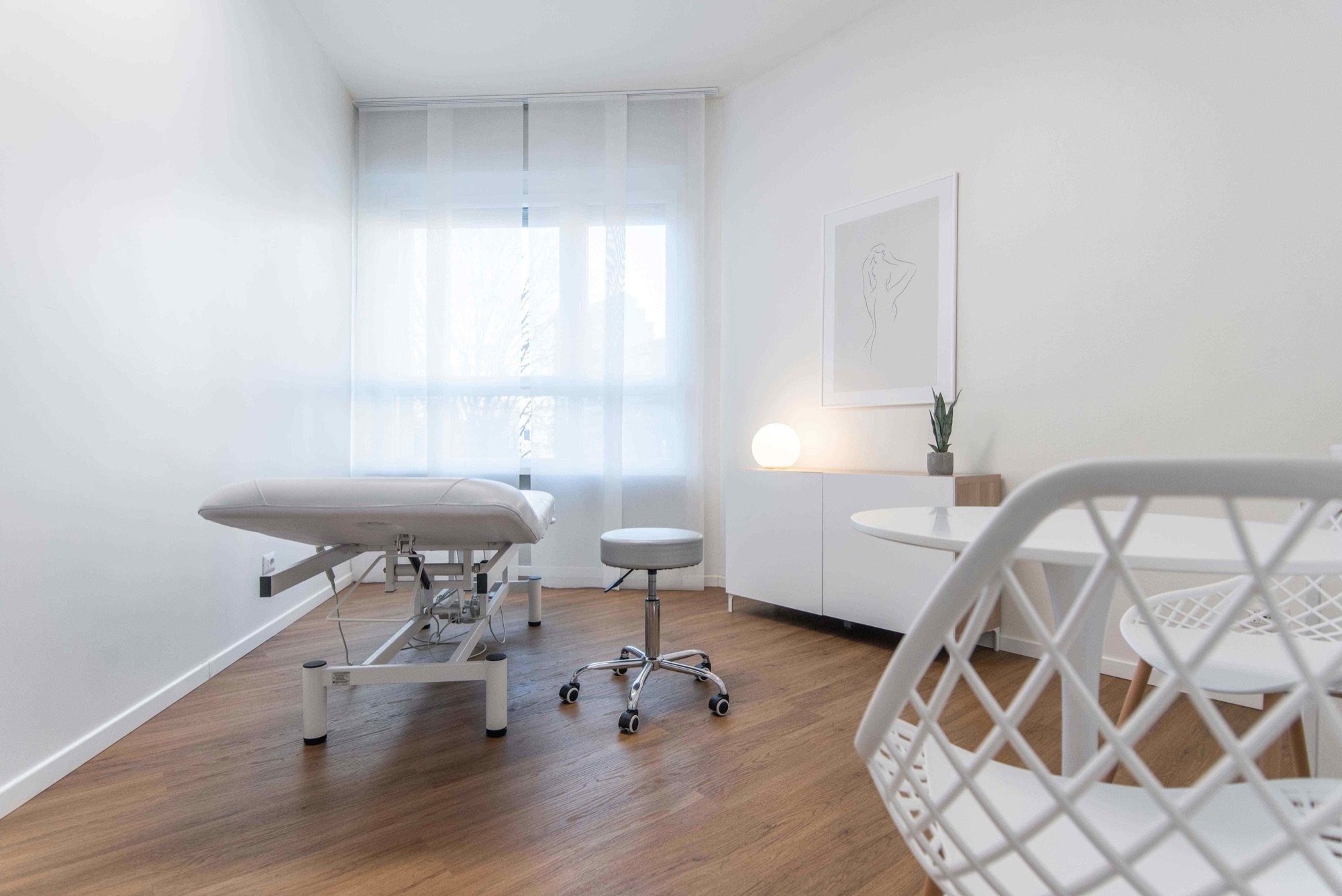 Lettino da visita con tavolino e sedia in primo piano in studio professionale Premium presso Spatium Porta Romana, Milano