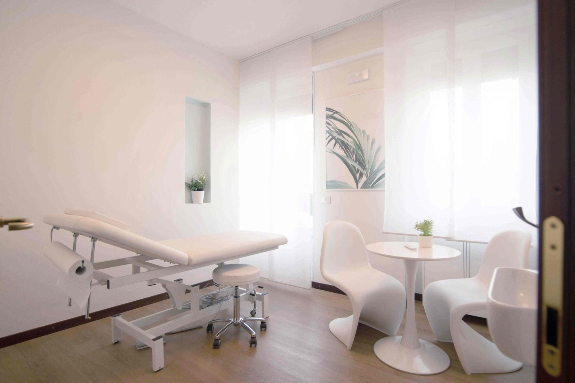 Lettino da visita con tavolino e sedute vicino alla finestra in studio professionale Premium presso Spatium Duomo, Milano