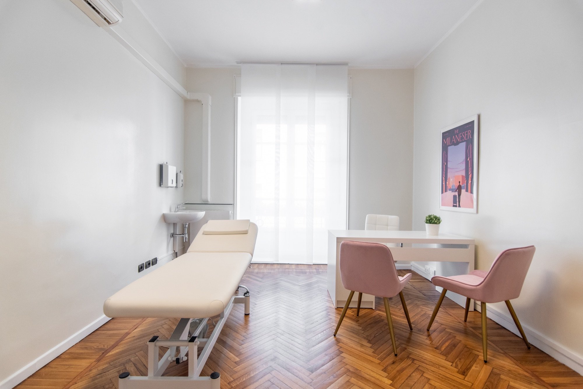 Lettino da visita con tavolo colloquio e sedute rosa in studio professionale Exclusive presso Spatium Santa Sofia, Milano