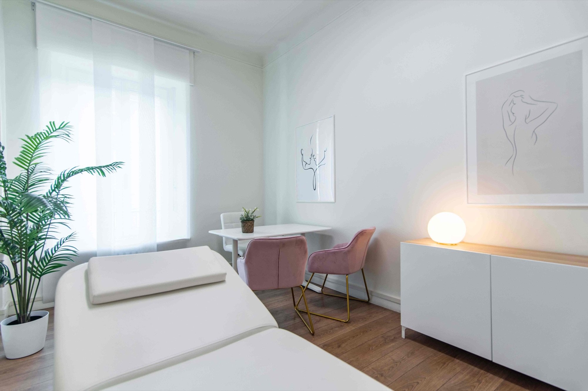 Lettino da visita in primo piano con tavolo e lampada in studio professionale Exclusive presso Spatium Policlinico, Milano