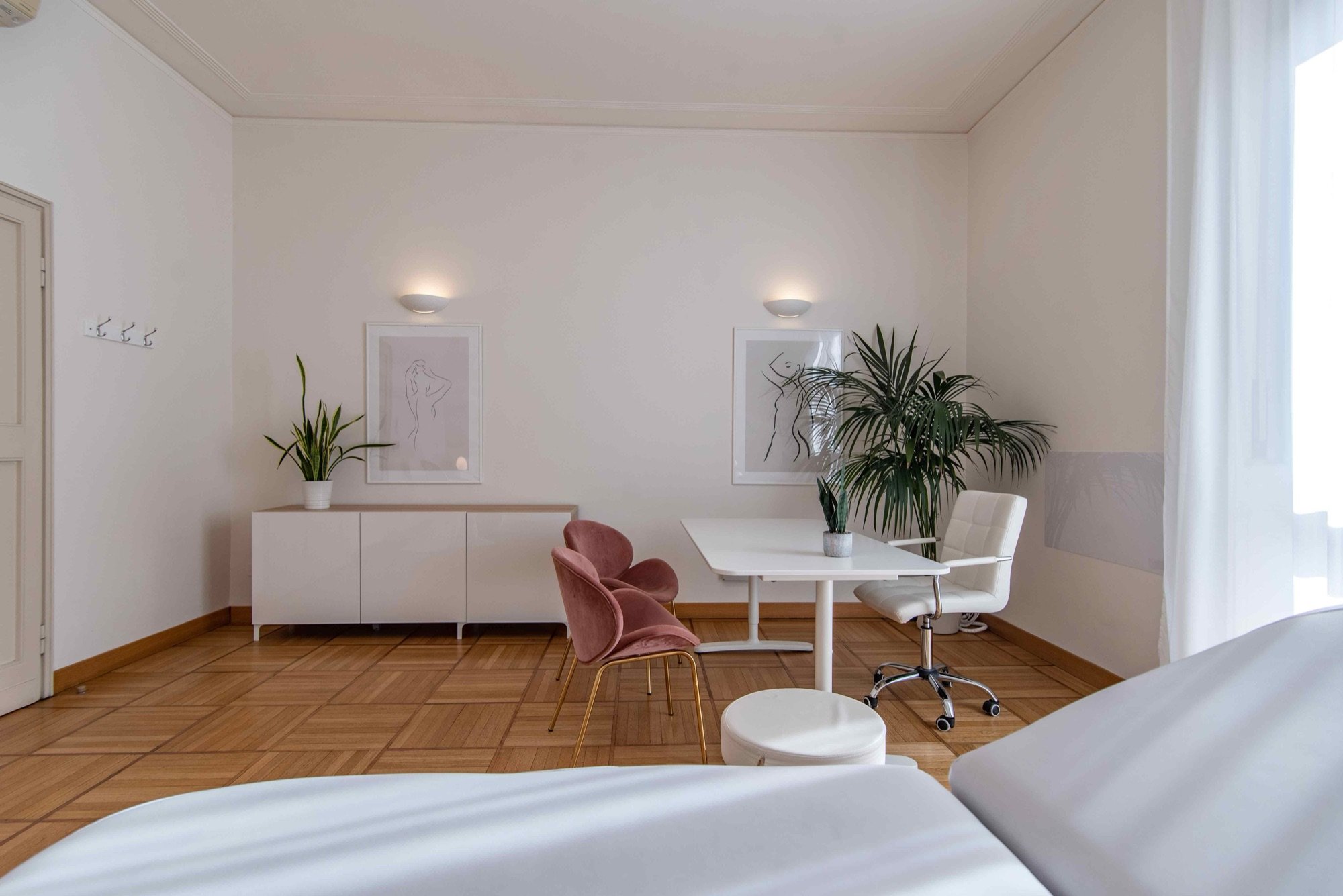 Lettino da visita in primo piano con tavolo e pianta in studio professionale Lounge presso Spatium Missori, Milano