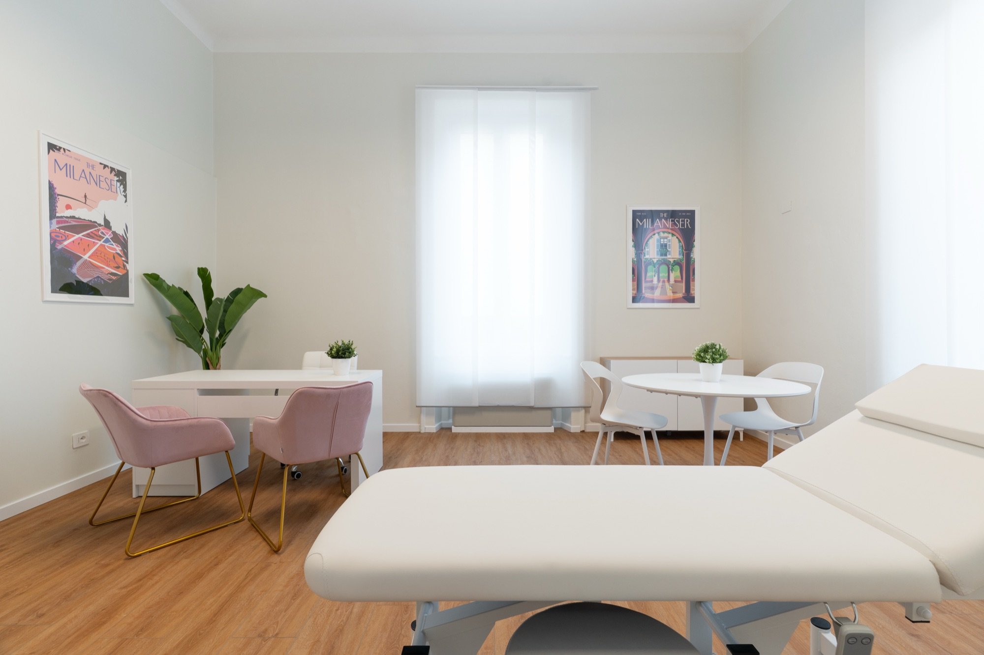 Lettino da visita in primo piano con tavolo e poltroncine rosa in studio professionale Lounge presso Spatium Corso Vercelli, Milano