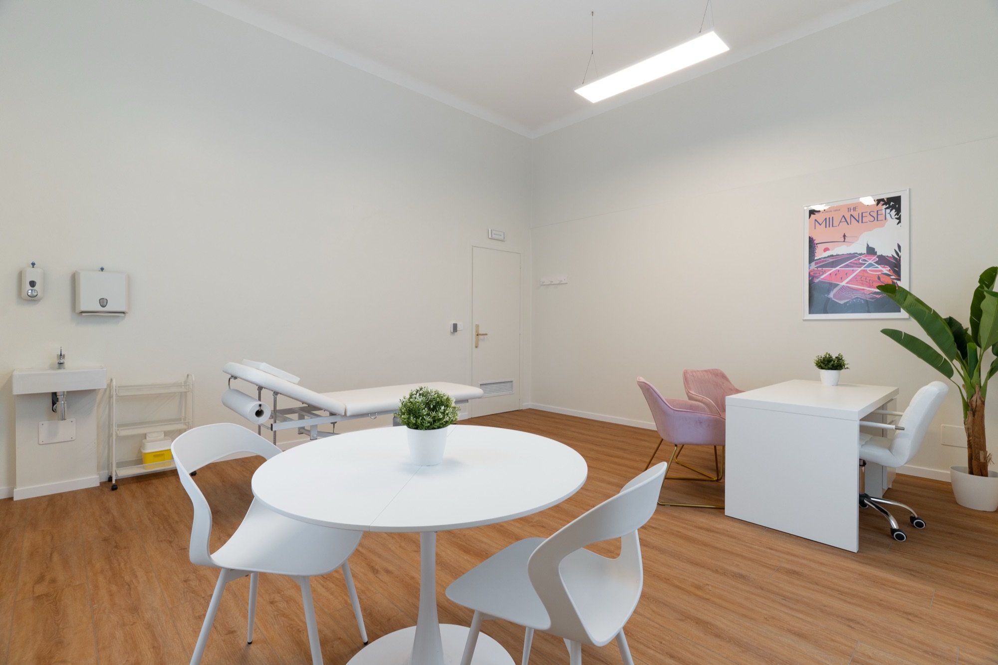 Lettino da visita con tavolo rotondo e sedute bianche in studio professionale Lounge presso Spatium Corso Vercelli, Milano