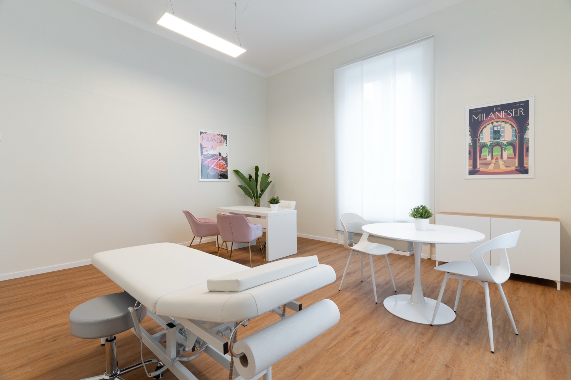 Lettino da visita con tavolo rotondo, sedute bianche e pianta in studio professionale Lounge presso Spatium Corso Vercelli, Milano