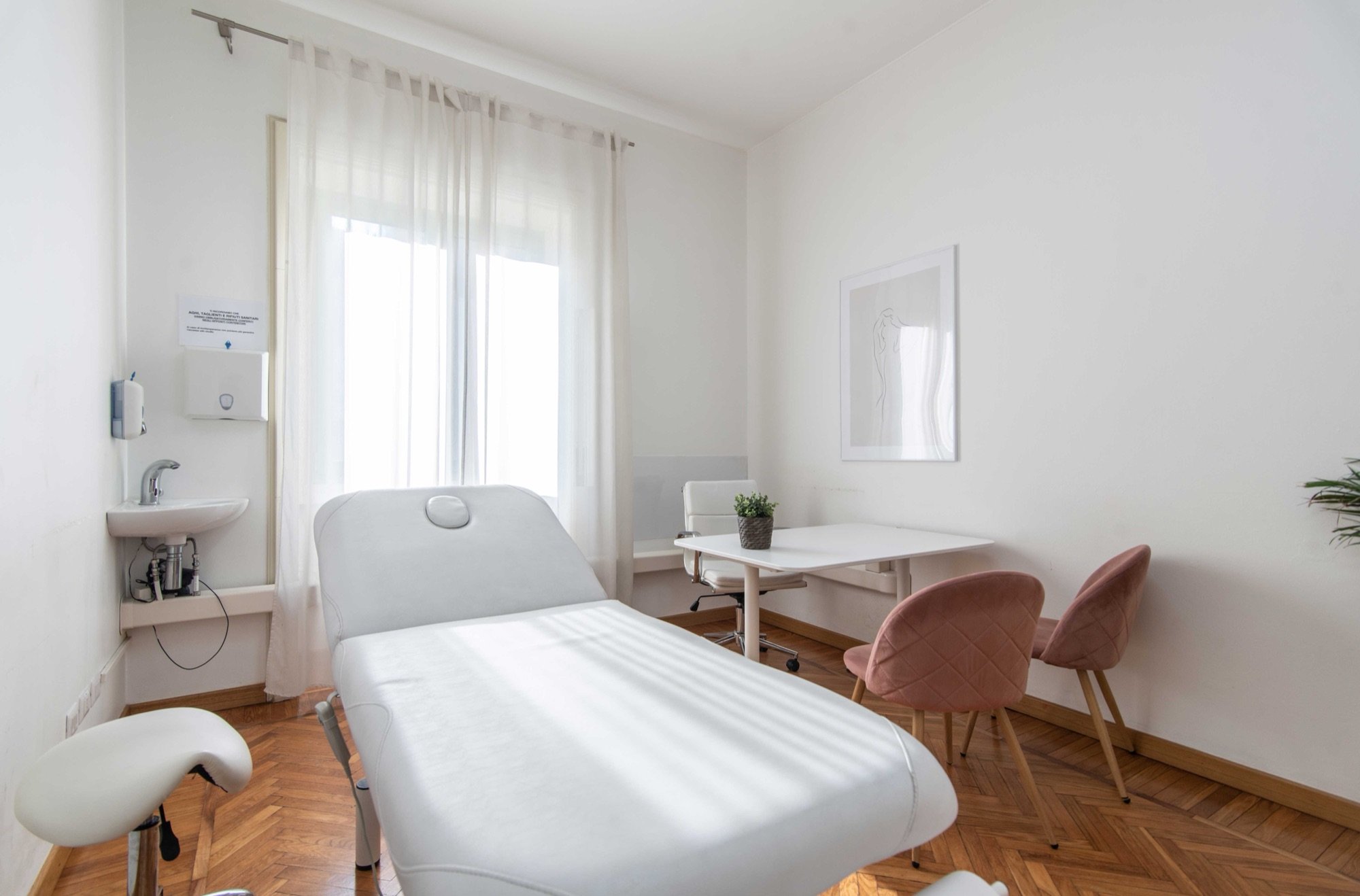Lettino da visita in primo piano con tavolo e sedute in studio professionale Exclusive presso Spatium Loreto, Milano